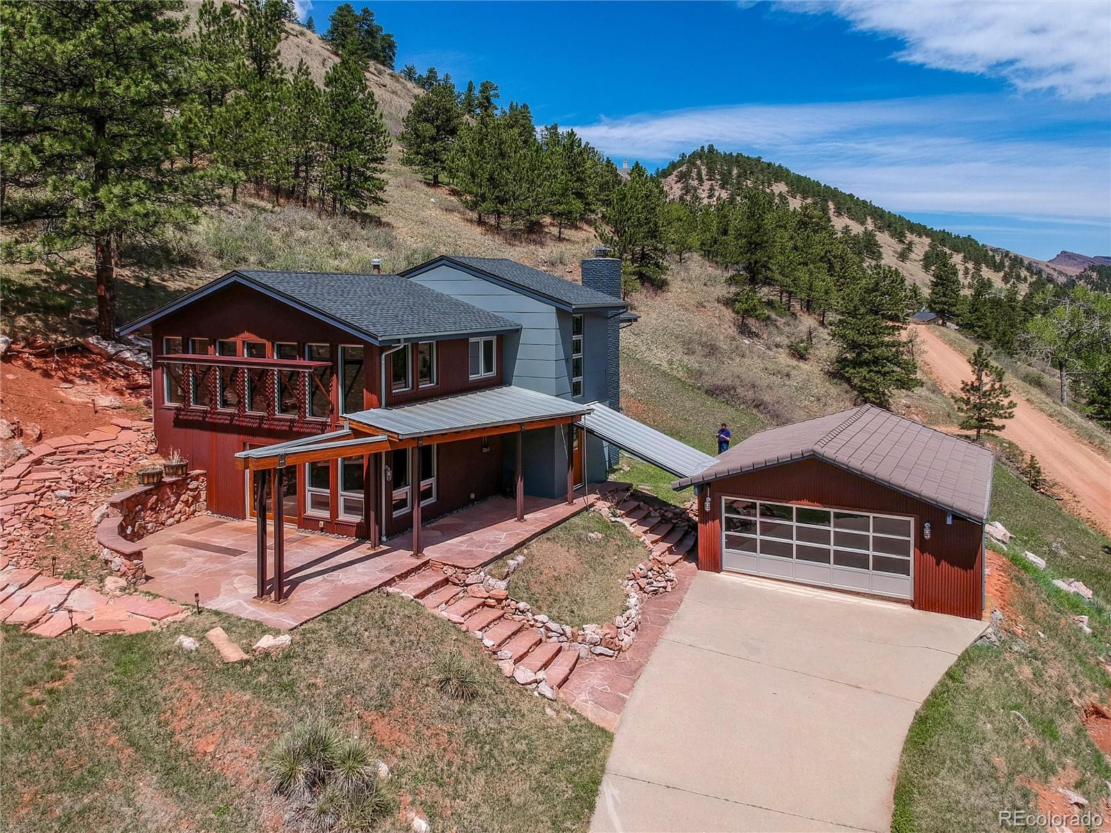 Featured in Colorado Homes & Lifestyles magazine after complete remodel in '09, this architectural marvel offers a rare blend of rugged mountain aesthetics and refined modern luxury. Step inside this 3/2 loft home--the ultimate entertainer's sanctuary, boasting sweeping unobstructed views of Olde Stage Canyon. Commercial aluminum windows soar throughout flooding the space with natural light. Anchoring the space is a striking metal encased fireplace that extends the height of the home. Every detail has been curated for the consummate host. The home is pre-wired for B&O sound system, features a wine cellar, sunroom, patio and porch(heated) for year round entertaining. Multiple lofts fill the vertical space. The layout flows seamlessly across natural slate floors on the main level to warm wood floors upstairs. The baths boast slate, concrete & steel incl cool light fixtures complete with Hansgrohe Axor Starck faucets/fixtures creating a spa like experience. Striking design features also include exposed architectural steel, a massive glulam beam, tension cable railings, spiral staircase and rusted corrugated metal siding. The drive thru garage features a striking commercial aluminum framed glass garage door. Enjoy peace of mind knowing there is an AHS Plus Home Warranty offered by the seller, new shingle roof(warranty/inspected) and new septic tank(inspected). 6709 Olde Stage Road is more than a home; its a living piece of art designed for those who love to celebrate in style!