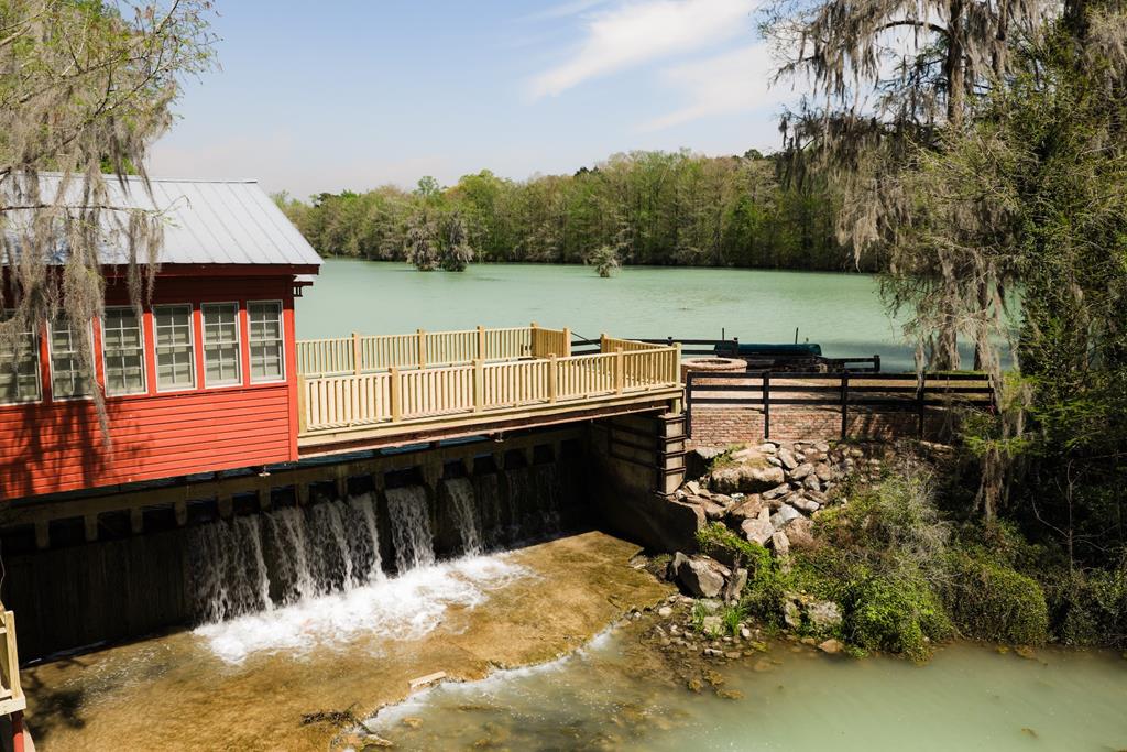To own Howard's Mill is to become the next steward of nearly two centuries of Southern history — and an opportunity to build an equally enduring legacy for the generations to come.  At the heart of the property stands the circa 1834 historic mill and its magnificent 40-acre millpond, fed by Howard's Mill Creek and a network of natural freshwater springs. Professionally managed for exceptional fishing, the pond is as productive as it is beautiful, with ancient bald cypress lining its shoreline. The mill itself began as a sugar cane operation before evolving into a grist mill, and the adjacent general store served for decades as the social and commercial center of the surrounding community of Jakin, Georgia. Generations of children learned to swim in the deep pool beneath the grist stones while neighbors bought staples, penny candy, and Coca-Colas at the country store.  The historic mill has been meticulously renovated into a private retreat of rare character, featuring one bedroom, two baths, and an open living area with a deck that extends over the millpond — a setting with few equals in the South. The original general store stands alongside it as a fully appointed guest suite, with a private bedroom, bath, and living area that opens onto grounds graced with hundreds of specimen camellias and azaleas. Together, these two structures form the nucleus of a genuine family compound: a gathering place with nearly two centuries of history and tradition steeped into its very fabric. Few properties anywhere in the region offer this combination of historic authenticity, intimate beauty, and the bones of a true multi-generational retreat.  The surrounding land reinforces the legacy. Classic quail woods aesthetics define the landscape, managed for bobwhite quail, with whitetail deer and turkey present throughout — a four-season recreational property of the first order. Sporting infrastructure includes a 12-run dog kennel, grain storage bins, and a pole barn. For those looking to expand their footprint, an additional 250 adjoining acres are available for lease, offering significant additional hunting and recreational reach.  There is no shortage of beautiful land for sale in the South. There is, however, a profound shortage of places like this — where history, beauty, and the makings of a true family compound converge in a single offering. Properties of this nature rarely come to market, and opportunities to own a piece of Southern history are rarer still. Howard's Mill is one of them.