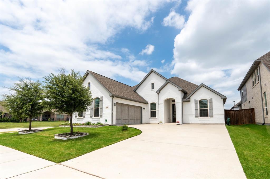 Better-than-new 2022 build in Rockwall's Stone Creek community, set on a premium corner lot just steps from the neighborhood pool, park, playground, and pond. This single-story home offers 4 bedrooms, 3 full baths, a dedicated home office, and 2,622 sq ft of open-concept living under soft tray ceilings. The bright kitchen anchors the space with a large center island, granite counters, walk-in pantry, built-in cabinetry, and stainless appliances including a gas cooktop and tankless water heater — all flowing into a spacious living room. The private primary suite features a spa-style bath with dual vanities, garden tub, separate shower, coffee bar, and generous walk-in closet. Out back, a covered patio with a gas fireplace and TV-ready wall overlooks a fenced yard, made for year-round entertaining. Crisp white-painted brick exterior, ceramic tile throughout, side-entry 2-car garage, and data flat-screen wiring add lasting value. Zoned to Rockwall ISD.