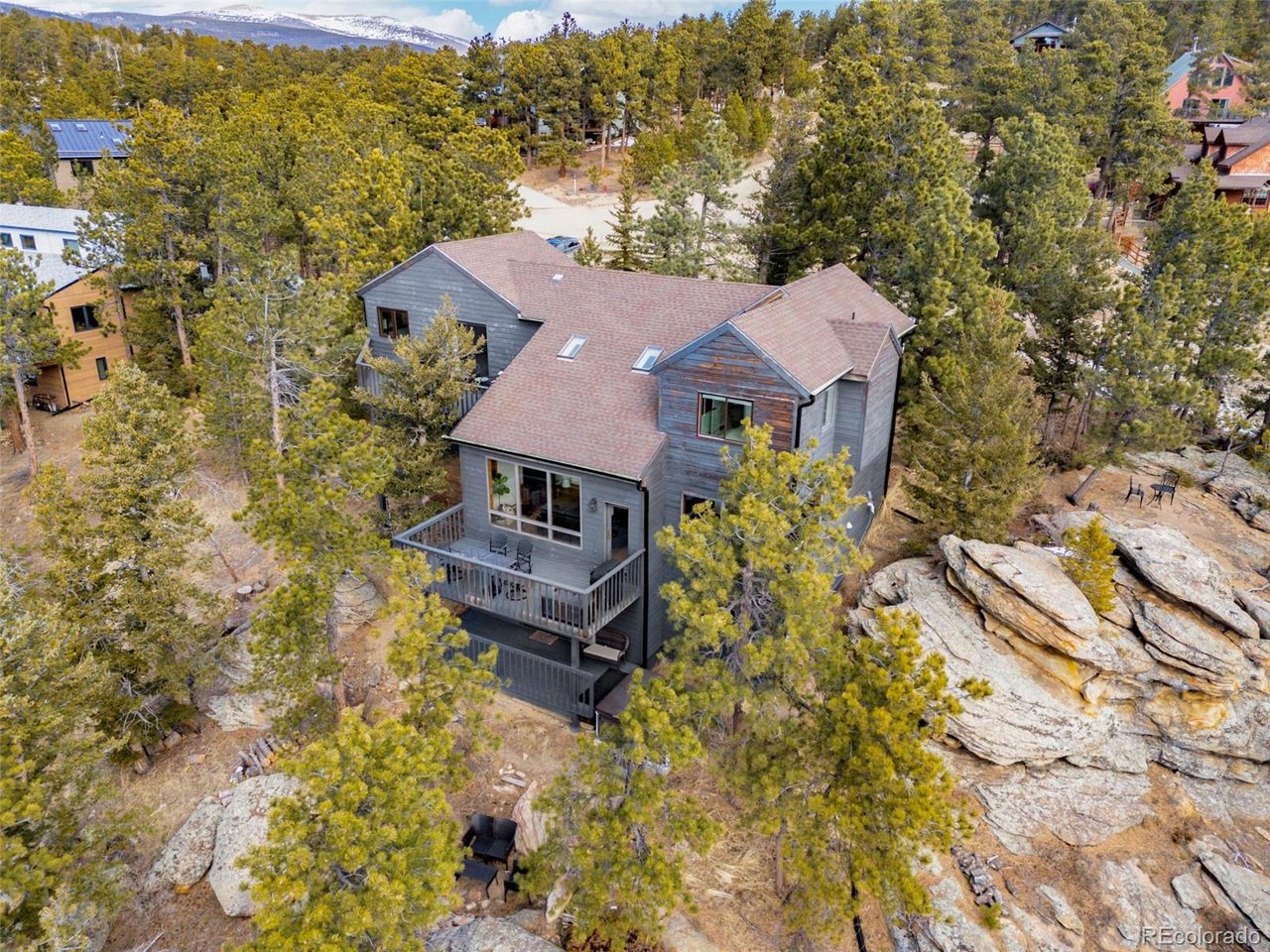 Spectacular location in Nederland's premier Sunnyside subdivision, overlooking the charming Town of Nederland with sweeping views of snow-capped peaks and surrounding mountains. This well-designed home features an open floor plan with a large air-lock foyer and sun-drenched spaces throughout, all oriented to capture incredible light and views. Nestled among beautiful rock outcroppings, this property offers a rare combination of privacy and convenience just a short walk to downtown Nederland, the elementary school, trails, restaurants, breweries, shops, grocery stores and the local movie theater. Enjoy quick access to outdoor recreation year-round, including nearby Eldora Ski Resort. Recent improvements include updated carpet and brand-new LVP flooring, along with updates to 3 of the 4 bathrooms. The primary suite is a true retreat with a private balcony showcasing Divide Mountain views, a versatile bonus room ideal for an office, yoga space, or nursery, a large walk-in closet and 5-piece bath. The walkout lower level has a separate entrance and has been thoughtfully converted into a successful short-term rental unit, offering excellent income potential ($22K in 2025) or flexible multi-generational living. Additional upgrades include a whole-house natural gas generator that automatically provides reliable backup power during outages. Set well back from the road, this private mountain home features 3 separate decks for enjoying the outdoors, ample storage throughout and a layout that offers both comfort, flexibility & mountain views. A rare opportunity to own a well-built home with strong bones, modern updates, unbeatable views and exceptional location in one of Nederland's most desirable neighborhoods.