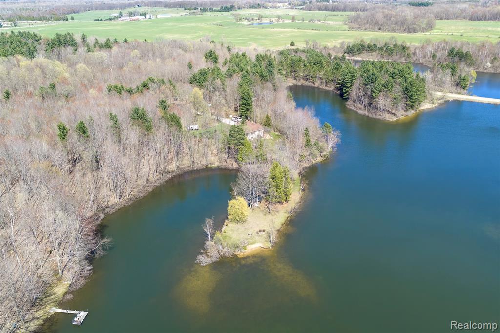 This truly unique property features 10 +/- wooded acres, over 2,000 feet of lake frontage, and a 5-bedroom, 2-bath ranch-style home, creating an outdoorsman’s paradise in Tuscola County. Situated on a 55 +/- acre lake shared by only 12 landowners and managed through an HOA, this property offers privacy, recreation, and long-term enjoyment.The surrounding timber provides ideal habitat for deer and turkey, while Evergreen Lake offers excellent fishing with many fish species including bass and bluegill. An established trail system allows you to walk, bike, or drive an ATV or golf cart around the lake, traveling over the dam and past the common beach and boat launch.The home offers 2,668 finished square feet, including a full finished basement with three additional bedrooms and a full bath, providing plenty of space for family and guests. Multiple daylight and egress windows provide scenic views of the wooded acreage and lakefront setting.Additional features include a 24 x 24 attached garage, 18 x 20 pole barn, geothermal heating and cooling system, a new deck, and a new roof installed in 2026, providing efficiency and peace of mind.Properties offering this combination of acreage, heavy timber, extensive lake frontage, and quality wildlife habitat are rarely available in Tuscola County. Whether you're seeking a full-time residence, recreational getaway, or investment property, this one deserves your attention.Location:• 7 miles to Kingston• 11 miles to Caro• 33 miles to Saginaw• 84 miles to Detroit• 100 miles to Lansing