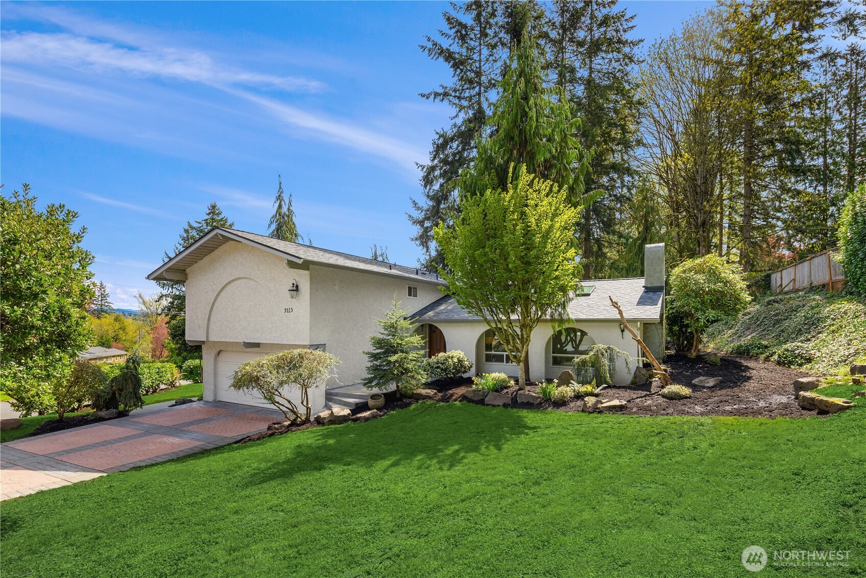 Mediterranean-inspired 5 bed, 2.75 bath southend Mercer Island home situated on corner lot, walking distance to schools. Open-concept main floor includes two spacious, light-filled living+dining areas, skylights and wood-burning fireplace. Kitchen is well-appointed with SS appliances+abundant cabinetry+built-in stove/grill combo. Upper floor has 4 generously sized bedrooms+two full baths. Lower level features a 5th bedroom+3/4 bath - perfect for guests or multi-generational living. Peek-a-boo lake views from primary and upper beds. French doors lead to private entertainer's paradise, complete with gas BBQ+firepit. Large flat side yard for play/gardens. New roof+fresh interior paint+refinished maple floors. Two car garage/EV charger.