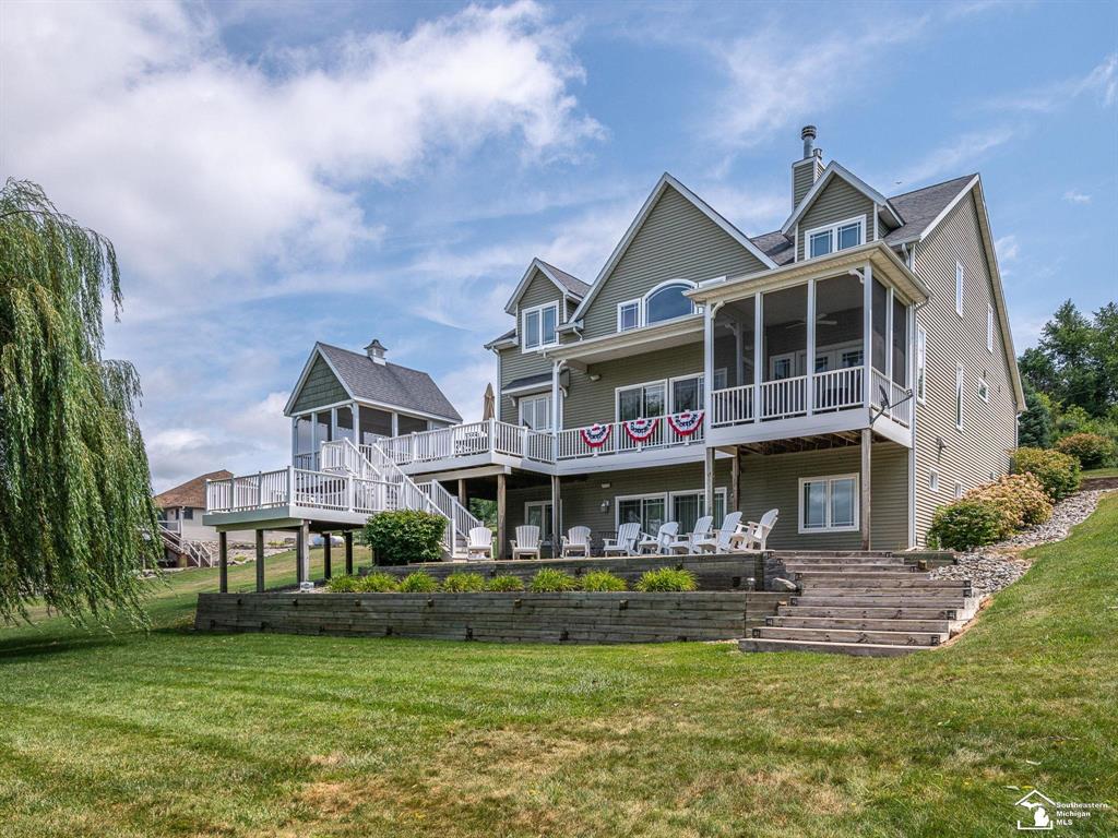 Spectacular 6 Acre Turnkey Lakefront Retreat on All-Sports Lake Diane!  Enjoy breathtaking views and unmatched lake living with this exceptional 8-bedroom, 3.5-bath home on 6 acres with 249 feet of frontage on Lake Diane. Spanning 6,088 square feet, this turnkey home offers space, luxury, and comfort for the ultimate family retreat or year-round residence. This home is truly one of a kind!  The bright and airy main floor open-concept design features a spacious living room with cathedral ceilings, gas fireplace, entertainment cabinet, built-in bookshelves/cabinetry, and panoramic lake views. The chef's kitchen is a true showpiece-complete with granite countertops, abundant cabinetry, custom hood with tiled backsplash and built-in pot filler, six-burner Five Star cooktop, and center island with storage. The dining area includes a charming window seat and pantry/storage cabinet.  The main floor primary suite offers a private retreat with a screened-in balcony perfect for your morning coffee or evening cocktails while enjoying stunning sunsets over the water. The bathroom features a tiled shower and double vanity. An additional main floor bedroom, spacious mudroom with bench/storage cubbies, pantry and storage closets and half bath complete this level.   Upstairs, you'll find four generously sized bedrooms, a full bathroom, a cozy sitting area and a balcony-style walkway overlooking the living room and lake.  The walkout lower level is tailor-made for lakeside entertaining, boasting a large family room with a second fireplace, a custom bar area, two additional bedrooms, full bathroom, laundry room, and storage areas.   Outdoor living is a dream with the beautifully landscaped grounds leading to your private dock, multiple outdoor living spaces, gorgeous balcony lake views, screened-in dining area, stamped concrete patio, built-in gas grill, and outdoor shower, provide endless spots to relax and take in the natural beauty. The property is equipped with geothermal heating, a Generac generator, and includes dock, boat l