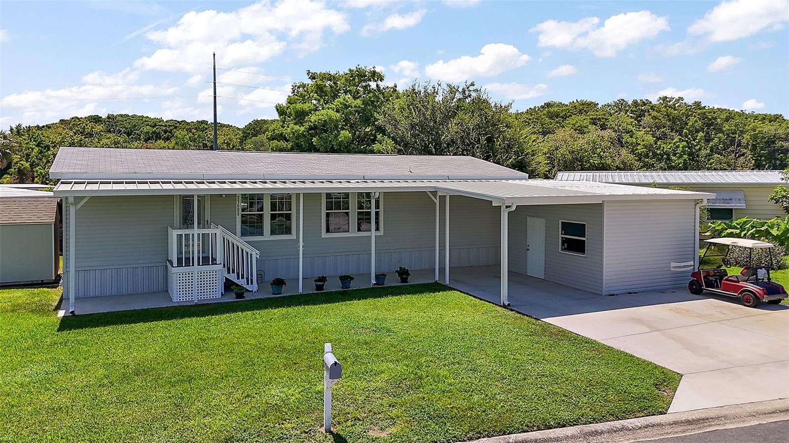 Come see this WATERFRONT 2 BED / 2 BATH / BONUS ROOM (UNFURNISHED) MODULAR HOME in the highly sought after IMPERIAL TERRACE WEST 55+ COMMUNITY IN TAVARES.  This 2021 TURNKEY home boasts CANAL FRONT living with Covered Boat House and Lift.  The BACK PATIO allows for serene canal views and gathering of friends.  A SIDE PORCH allows for shade to enjoy your cup of coffee and relax!  The natural light streams into a spacious recessed-lighted KITCHEN with FORMICA COUNTERTOPS, including the BREAKFAST BAR, open floor plan LIVING ROOM and DINING ROOM.  CROWN MOLDING and WOODEN VALANCES accent throughout the home.  All Whirlpool APPLIANCES - ELECTRIC STOVE, REFRIGERATOR WITH ICEMAKER, MICROWAVE, DISHWASHER, WASHER and DRYER are four years old.  The PRIMARY BEDROOM/ENSUITE is spacious, including Sink/Vanity, Walk-In Shower and Closet.  The BONUS ROOM is an added extra!  WASHER and DRYER are inside the home.  The exterior has TWO SPACIOUS SHEDS - one attached to the home and the other bolted down to a concrete slab, a CARPORT and  driveway with enough room for THREE VEHICLES and a GOLF CART.  The BOAT LIFT and REINFORCED BOATHOUSE were recently upgraded.  A WELL on the property backside allows for grass watering with the in-ground SPRINKLER SYSTEM.  There is also a PEST GUARD SYSTEM in-place around the outside perimeter.  TIE-DOWNS complete the home along with "YOU OWN THE LAND" for ease in insuring.  The neighborhood includes a Community Clubhouse, an In-Ground Swimming Pool, Jacuzzi Tub, and plethora of COMMUNITY ACTIVITIES throughout the year - all for the LOW HOA of $25/MONTHLY.   Within a short driving distance are Dining, Shopping, Medical Providers and Quaint Shoppes.  Call to schedule your tour today!