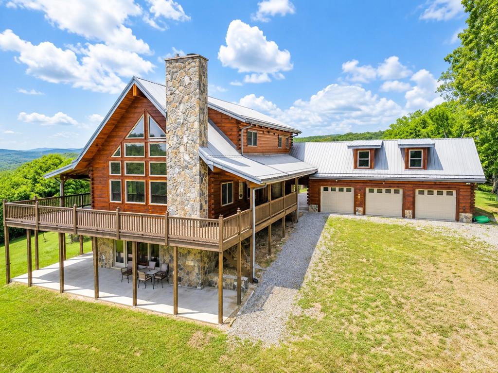 Experience Blue Ridge Mountain living at its finest with this stunning 4 bedroom, 3.5 bath home situated on over 6 private acres at a high elevation with truly unmatched long-range views. The main level features soaring cathedral ceilings, beautiful hickory flooring, a spacious living area with a stone fireplace, and a well-appointed kitchen with granite countertops. The primary bedroom and bath are also located on the main level, along with a convenient half bath. Upstairs offers two additional bedrooms, a full bath, and a large loft overlooking the living area. The finished lower level provides even more living space with a large den, stone fireplace with wood stove insert, bedroom, and full bath, making it ideal for family, guests, or entertaining. Relax on the wraparound porch and enjoy the privacy, peaceful mountain setting, breathtaking views, and unforgettable sunsets over the Blue Ridge Mountains. Additional features include a 3-car garage with storage above, all while being conveniently located near the New River, Independence, VA, and Sparta, NC.
