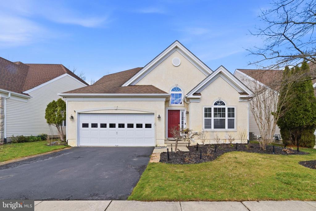 Welcome to 23 Lowell Drive, located in the highly desirable Legacy Oaks community in Marlton, one of South Jersey’s premier 55+ neighborhoods known for its active lifestyle and resort-style amenities. This well-maintained 3-bedroom, 3-bath home offers a spacious and functional layout highlighted by soaring vaulted ceilings and an open-concept design that makes everyday living and entertaining effortless. Upon entry, you’re greeted by formal living and dining spaces, ideal for hosting gatherings or enjoying quiet evenings at home. The kitchen serves as the centerpiece of the home, featuring 42-inch maple cabinetry, a center island for added prep space, a pantry with pull-out shelving, and a full appliance package. A bright breakfast area flows seamlessly into the family room, where vaulted ceilings create an inviting and comfortable atmosphere. Just beyond, French doors lead to a sun-filled sunroom overlooking a peaceful, park-like backyard. Step outside to the patio, perfect for outdoor dining or relaxing in a private setting. The main-level primary suite is conveniently located off the family room and offers a spacious retreat complete with a walk-in closet, double vanity, soaking tub, and separate shower. A second bedroom and full hall bath are also located on the first floor, along with a generously sized laundry/mudroom that provides access to the attached two-car garage. Upstairs, you’ll find a versatile loft area, an additional bedroom, and a full bath—ideal for guests or extended living space. A walk-in attic adds valuable storage or potential for a hobby or workshop area. Additional highlights include hardwood flooring throughout much of the main level, recessed lighting, a security system, and an in-ground sprinkler system. Residents of Legacy Oaks enjoy access to a beautifully appointed clubhouse with a fitness center, billiards room, library, card room, heated outdoor pool, and tennis and bocce courts. Conveniently located near shopping, dining, and major roadways, this home offers both comfort and accessibility. Don’t miss the opportunity to make this exceptional home your own—schedule your showing today!