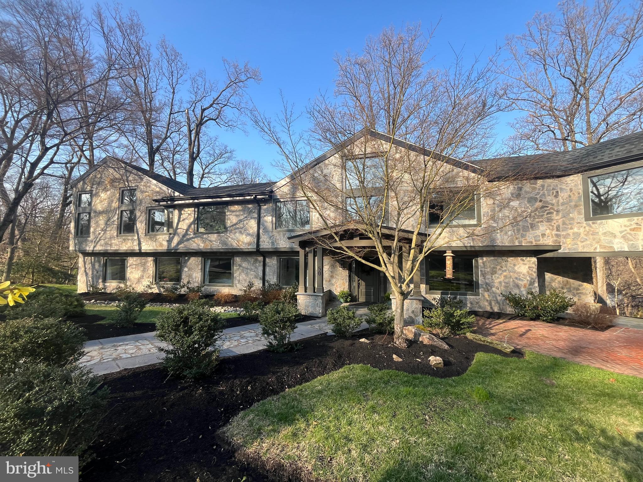 Stunning home on one of Penn Valley’s most desirable streets. Extensively renovated in 2019, this exceptional custom home offers 6 bedrooms, 7 full baths, and 1 half bath across more than 8,000 square feet of beautifully designed living space. Privately situated on a 2.78-acre interior lot, the home showcases a sophisticated transitional style, oversized windows, and wide-plank hardwood floors that have just been newly refinished.A striking entry opens to an expansive, light-filled layout where the grand kitchen and dining area flow seamlessly into a breathtaking two-story great room. Featuring exposed beams, a dramatic floor-to-ceiling stone gas fireplace, and walls of glass, this space leads to a serene rear deck overlooking the landscaped grounds and resort-style pool.The chef’s kitchen is both elegant and functional, complete with a massive quartz waterfall island, custom wood cabinetry, dual sinks, two dishwashers, and high-end stainless steel appliances. The main level also includes two bedroom suites with private baths, a dedicated office, and a powder room.Upstairs, two luxurious primary suites provide exceptional comfort and flexibility. The main suite boasts vaulted ceilings, custom built-ins, a spacious walk-in closet, and a spa-like bath with dual vanities, soaking tub, and oversized shower. The second suite features vaulted ceilings, a lofted sitting area or office, walk-in closet, and a beautifully appointed bath with dual vanities and a large walk-in shower. This level also includes an additional bedroom suite, a full laundry room, and an expansive theater room with its own full bath.The finished walk-out lower level offers incredible versatility, ideal for an au pair or in-law suite. With a private entrance, it includes a bedroom with walk-in closet, full bath, second laundry room, and a large recreation or playroom.The lush, private grounds are perfect for relaxing or entertaining—whether enjoying the pool, dining al fresco, or unwinding on the patio. Complete with a 3-car garage equipped with an EV charger, this home offers both luxury and convenience. Located in the award-winning Lower Merion School District and just minutes from Narberth, Gladwyne Village, and major commuting routes to Center City, this move-in-ready residence is a rare opportunity not to be missed.