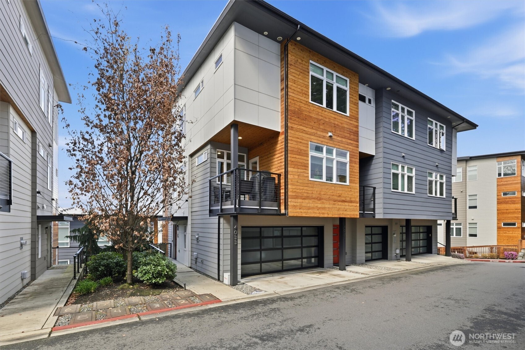 Live at the center of Eastside convenience in Newport Commons, where shopping, dining, schools, parks, and major commuter routes are all within easy reach. Walk to Factoria Mall, T&T Superstore, restaurants, Tyee Middle School, and Newport High, with quick access to I-90, I-405, Bellevue, and Seattle. Built in 2019, this beautifully crafted townhome offers a light-filled main level with rich hardwood flooring, crown molding, shiplap accents, and an open-concept layout designed for everyday living and entertaining. The well-appointed kitchen features custom pull-out shelving for smart, effortless organization. Three spacious bedrooms each offer a private ensuite bath, providing exceptional flexibility for household members, guests, or multigenerational living. A dedicated office creates an ideal work-from-home space, while the lower-level flex room can serve as a media room, playroom, fitness area, or guest retreat. Custom built-ins in the foyer and garage maximize storage, while an attached 2-car garage with EV charger completes this thoughtfully designed home.