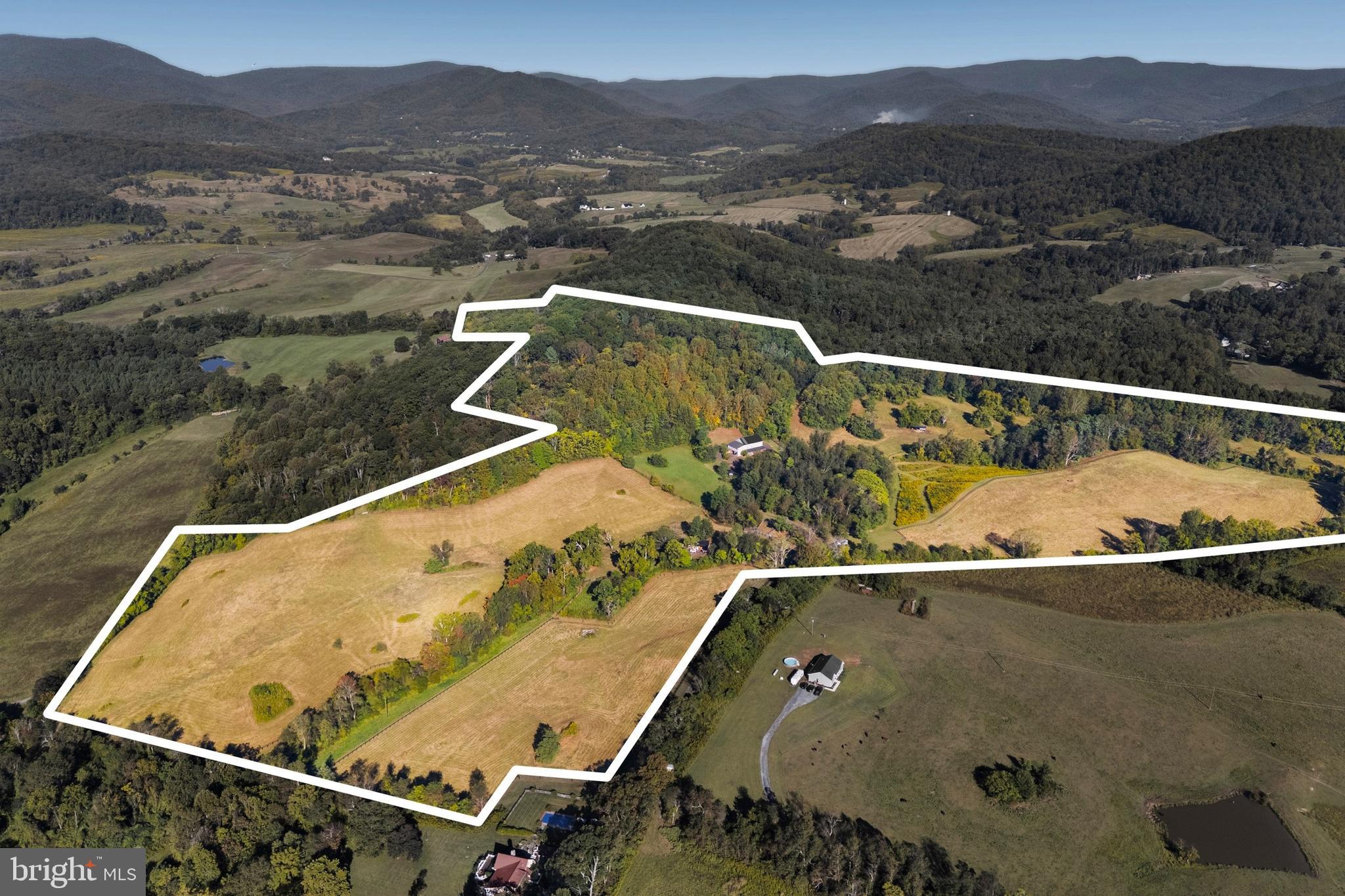 Do you dream of room to roam in the rolling foothills of Rappahannock County? Fox Hill is a dream come true in the heart of Virginia's Piedmont. Verdant pastures undulate and meet lush forest on the flanks of Mason Mountain. Take in the ever-present views of Piedmont hills, Blue Ridge Mountains and your own private, hidden oasis. This sprawling property is 75 acres in two tax map parcels.  Fox Hill prominently features a stunning 1800s timber frame bank barn, which was rebuilt on site in 2018. Built on a new, poured concrete foundation, the lower floor is a well-appointed horse stable with 8 stalls, wash stall, feed room, and a sunny tack room with a full bath and kitchenette.  The upper floor has a very comfortable 1-bedroom apartment at its southern end. It is thoughtfully designed with high ceilings and oversized windows to let in the light. There is a bath with heated slate floors, a generous walk-in closet, and details like antique barn wood trim. The structure has Hardiplank siding and a standing-seam metal roof, providing low maintenance and longevity.  In addition to the apartment, the upper floor of the barn has a breathtaking, 3-story unfinished space. With a striking modern glass wall and door at the entrance, and authentic pegged timber frame construction, possibilities abound. This could be a stunning expansion of the living space, an impressive event venue, or maybe a tasting room for a farm winery or brewery. A septic system for 5 bedrooms is already in place and allows for either building a separate home uphill of the barn, or converting the barn space.  Fox Hill has 5 separately fenced pastures, a large run-in shed for horses, automatic waterers, and cattle sorting and loading infrastructure. Additionally, there is a machine shop/shed with electricity and a woodstove-heated workspace. The property is in the heart of the Thornton Hill Hounds foxhunting territory and is a short drive to several other hunts. Historic Warrenton and Upperville horse show grounds are each around an hour's drive, as are many other training and show facilities.  Rappahannock and surrounding counties offer endless recreational possibilities. Nearby Shenandoah National Park is home to scenic Skyline Drive with its overlooks as well as many miles of trails. There are wineries and breweries, great restaurants and cafes, antique stores, farms and orchards, and much more. Looking for cultural activities? Visit one of the many art galleries, attend a play or a concert at one of the theaters, or visit the Rappahannock Historical Society’s museum.  Near Sperryville and “little” Washington, and convenient to Warrenton and Culpeper, Fox Hill is ideally situated for full-time residents or weekenders alike. Located less than two hours from Washington, DC, and just over an hour from Charlottesville, the property is within an easy driving distance for weekend getaways.