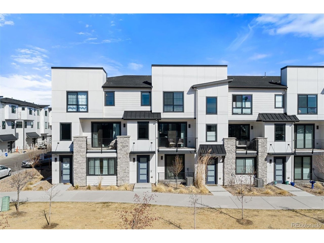 RARE COURTYARD LOCATION OVERLOOKING GREEN SPACE WITH MOUNTAIN VIEWS - A UNIQUE AND HIGHLY DESIRABLE RESIDENCE! This nearly new 2022 Henry floor plan is quietly positioned on a private courtyard and represents a setting seldom available within the community - one of the better positioned homes with rare courtyard orientation, open green space views, and mountain views. The well-designed three-level layout provides exceptional privacy with a dedicated bath for each bedroom, creating a highly functional design ideal for guests, roommates, or work-from-home flexibility. The ground level features a private bedroom with adjacent full bath, perfect for guests, a home office, or flexible living. The main living level showcases open-concept living centered around a spacious gourmet quartz island kitchen upgraded with La Plata Peak quartz countertops, stainless steel gas range, enhanced cabinetry, and designer backsplash. The kitchen flows seamlessly into the dining and living areas and opens to a private balcony with mountain views, creating an ideal setting for both everyday living and entertaining. Upstairs, the primary suite features an oversized walk-in closet, dual vanities, large shower, and generous counter space, while a secondary bedroom with en-suite bath and conveniently located upper-level laundry complete the top floor. Additional upgrades include Kohler plumbing fixtures, modern iron stair rails, extended flooring in the great room, enhanced lighting package, front-load washer and dryer, and central air conditioning. Additional highlights include south-facing exposure, covered front porch, smart garage technology, and an attached two-car garage with storage. Ideally located near I-25, Evans Avenue, and light rail with direct access to the Cherry Creek Trail, and just minutes to Washington Park, Platt Park, the University of Denver, Cherry Creek, and the Denver Tech Center. Completely move-in ready! WWW.2074SHOLLY.COM