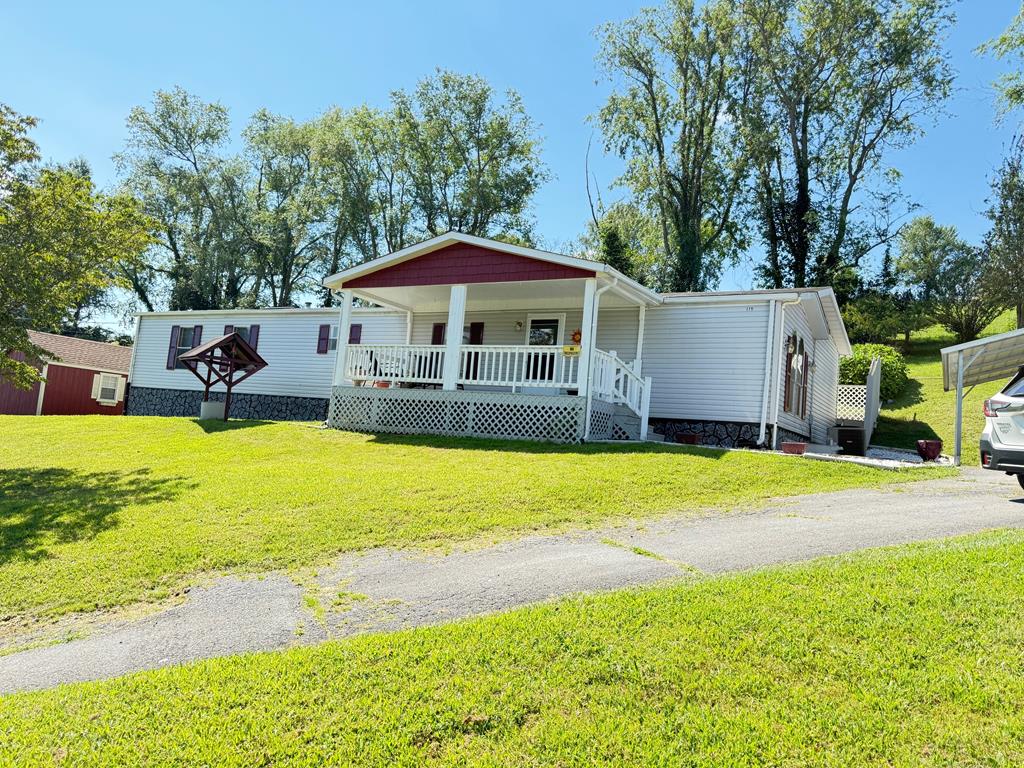Nestled in the heart of scenic Smyth County, Virginia, this 3-bedroom, 2-bath single wide mobile home offers 1,250 sq. ft. of comfortable living space and a peaceful setting. Step inside from the covered front porch into the inviting living room, featuring laminated wood flooring that flows throughout all three bedrooms. The eat-in kitchen is fully equipped with stainless steel appliances including a refrigerator, dishwasher, range/oven, and microwave. You'll also appreciate the spacious walk-in pantry—perfect for extra storage. The primary bedroom boasts a walk-in closet and an ensuite bathroom for added convenience and privacy. Enjoy the bonus of a den/family room with vinyl flooring that opens to the rear open deck—ideal for relaxing or entertaining. Just inside the den, there is a designated double door laundry area. New light fixtures have been installed throughout the home, providing a fresh and updated feel. Outside, the property features a handy workshop at the rear and a 400 sq. ft. detached 2-car carport. The home is clad in durable vinyl siding with a shingle roof and is connected to public water and sewer services through the Town of Chilhowie. This property is being sold AS-IS, offering a wonderful opportunity to own an affordable home in a beautiful location. Don't miss your chance to make this one your own!