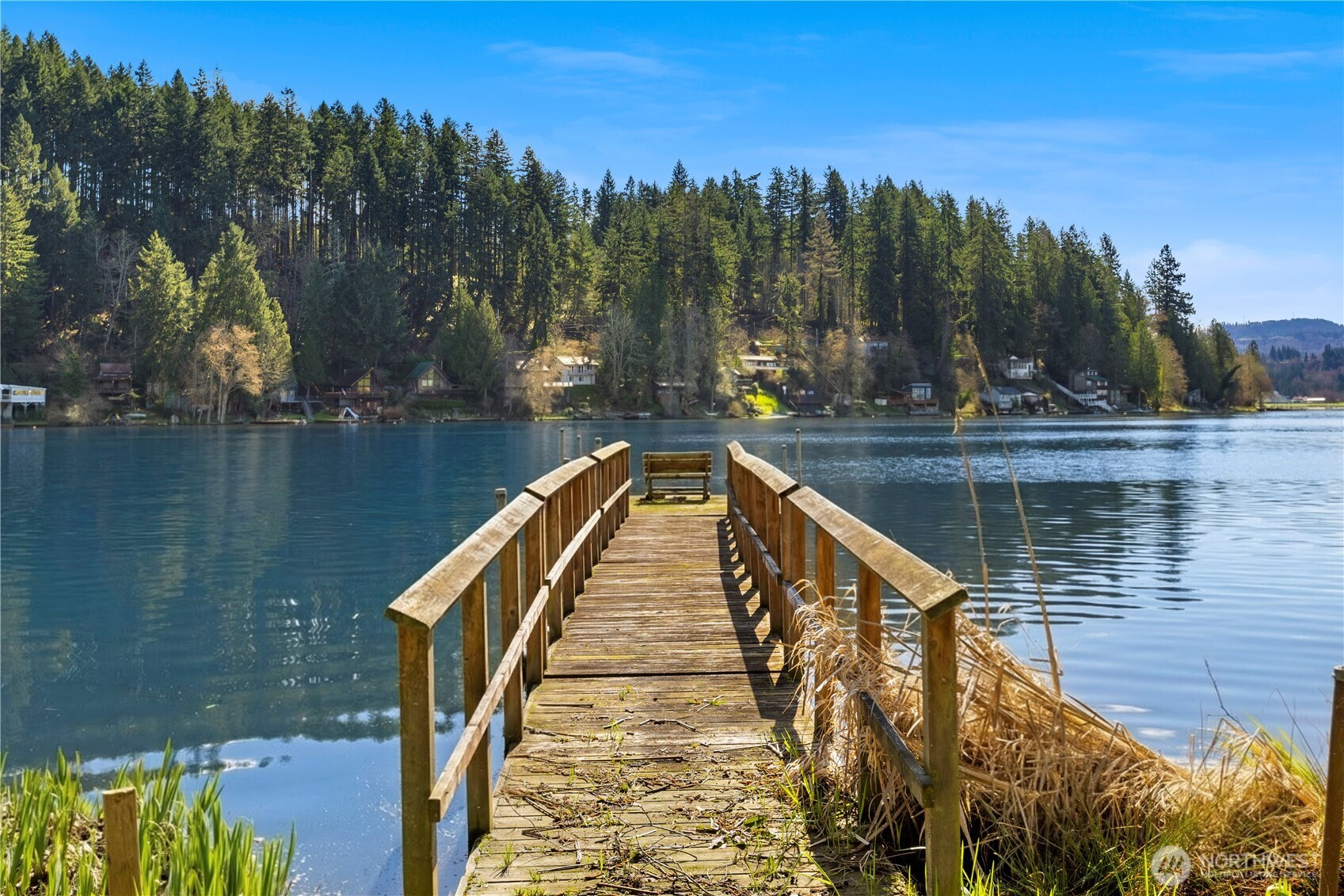 A rare opportunity to own 60 feet of no-bank waterfront on coveted Ohop Lake. This charming 1-story cottage is perfectly positioned to capture wide, panoramic lake views and open green space. Inside, you’ll find a bright, easy layout with an open living and dining area centered around a cozy wood stove. Two bedrooms and a ¾ bath keep things simple and comfortable. Step outside to the east-facing wraparound deck, your front-row seat to sunrise coffee, birdsong and glassy morning water. The expansive dock invites long summer days of boating, paddleboarding, or simply relaxing at the lake’s edge. Thoughtful updates include a newer septic (‘25), hot water tank, private well, and fresh exterior paint (‘23). Just about an hour from Seattle it's the perfect balance of escape and convenience. Low-maintenance living, it’s ideal as a personal getaway or year-round vacation rental income. Ohop Lake’s ski hours (11:00am–3:30pm) bring the fun when you want it, while mornings and evenings are reserved for peaceful cruising at 8mph or less. If you’ve been waiting for a true lakelife, this is it!
