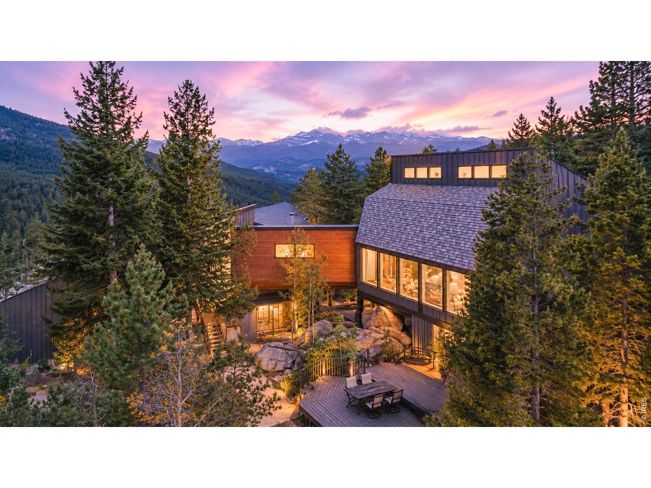 Live where you play in the Colorado Rockies! Set on 5 private acres in scenic Coal Creek Canyon among towering pines and dramatic rock outcroppings, this extensively renovated mountain retreat offers privacy, architectural character and unique views-both intimate and far away-from surrounding forest and rock formations to sweeping vistas of the Continental Divide and Indian Peaks. Soaring ceilings and expansive windows define both sides of the home, filling the interiors with natural light. An elegant combination of mountain rustic, mid-century modern and clean contemporary design creates a style that feels warm yet sophisticated. The main residence offers a kitchen, dining area, living room anchored by a striking stone fireplace, and 3 bedrooms. The primary bedroom includes a loft perfect for an office or reading space. New and refinished hardwood floors and new carpet complete the main home. A distinctive catwalk connects the two sides, each with its own private entrance and kitchen. The second living area features soaring ceilings, kitchen, sunroom, bathroom, laundry and a large open living area. The flexible layout creates opportunities for multi-generational living, extended guests, offices, media room, exercise room or studio, with potential for Airbnb/short-term rental use subject to applicable regulations. Extensive updates include a new roof, steel and real Shou Sugi Ban siding, continuous exterior insulation, new Marvin fiberglass windows, new exterior doors, upgraded plumbing and electrical, and radiant heat. The deck and rebuilt balcony showcase the mountain setting, while the 3-car garage offers ample storage and EV charging capability. High Speed Fiber internet makes remote work easy. Eldora is approx. 30 minutes away, with Gross Reservoir and Golden Gate Canyon State Park about 20 minutes away. Enjoy a scenic approx. 30-minute drive through Coal Creek Canyon to Boulder or Golden. Step outside for Colorado sunsets, stargazing and year-round recreation.