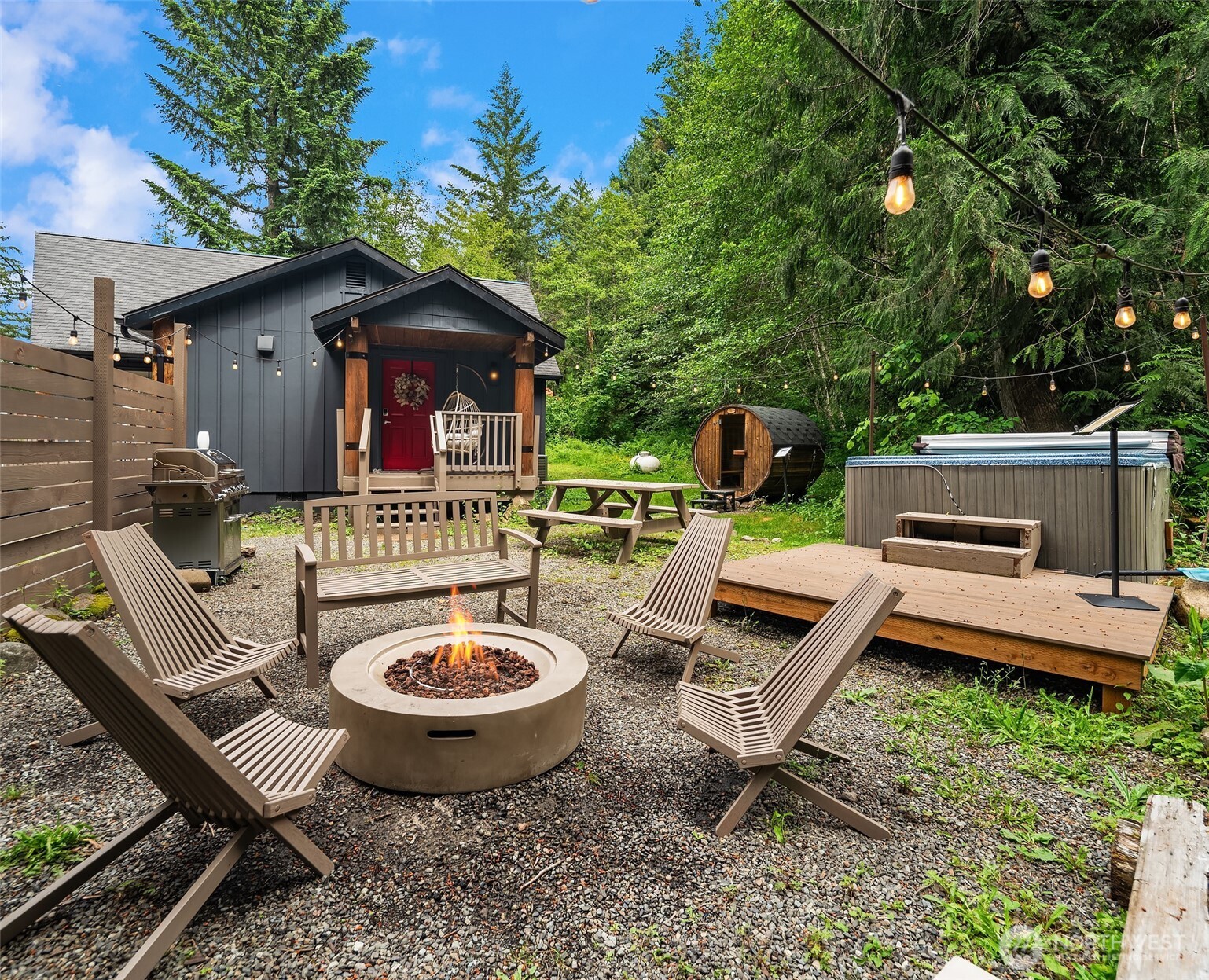 Nestled within tall evergreens near the end of a quiet and easily accessible private road is the Rainier Forest Cabin. This highly productive short-term rental is designed for groups looking for a relaxing weekend with amenities including an outdoor hot tub, barrel sauna, fire pit, fully stocked kitchen, and two queen rooms plus a bunk room for 4. Guests come for ski reunions, girls’ weekends, hiking groups, bachelorette parties, and family getaways. The open concept main living room features lofted ceilings, perfect for gathering with friends, playing games, or watching a movie next to the propane fireplace. Producing more than $100k gross rental income annually and offered fully furnished, this turnkey property is ideal if you’re looking to offset your cost of ownership or for an easy-to-operate short-term rental investment with a Tesla EV charger on site. Packwood is the basecamp to Mount Rainier (20 mins), White Pass (25 mins), and Gifford Pinchot National Forest, and offers residents and guests an assortment of mountain-town shopping, delicious dining, breweries for all ages, and world-class recreation.
