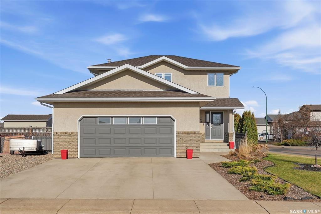 Experience elevated family living in one of Warman’s most desirable locations. Perfectly positioned on an expansive corner lot just steps from a picturesque man-made lake and scenic walking paths, this fully developed home blends comfort, space, and modern sophistication.  Offering 5 bedrooms and 4 bathrooms, this residence showcases extensive upgrades throughout, including fresh newer paint, modern trim, stylish LED lighting, new faucets, new toilets, a new fridge + dishwasher and upgraded flooring on the 2nd floor, basement as well as the bathrooms. The open-concept main floor is thoughtfully designed for both everyday living and upscale entertaining, featuring a spacious kitchen with a large island, stainless steel appliances, and abundant cabinetry, seamlessly flowing into the dining area and elegant living room highlighted by a striking gas fireplace.  Step outside to your private backyard retreat—fully landscaped and fenced—complete with a tiered deck, pergola, garden space, and lush green surroundings.  The upper-level hosts three generously sized bedrooms, including a serene primary suite with a walk-in closet and a spa-inspired ensuite featuring a jetted tub. The fully finished basement expands your living space with a large family room, two additional bedrooms, and a full bathroom—ideal for guests or growing families.  Additional features include a heated double attached garage with direct entry, main floor laundry, ample off-street and RV parking, central air conditioning, underground sprinklers, and room to add a secondary garage if desired.  A rare opportunity to own a refined, move-in-ready home in a premier location.  Loft style bunk beds included. Tire racks in the garage not included.  Call to view.