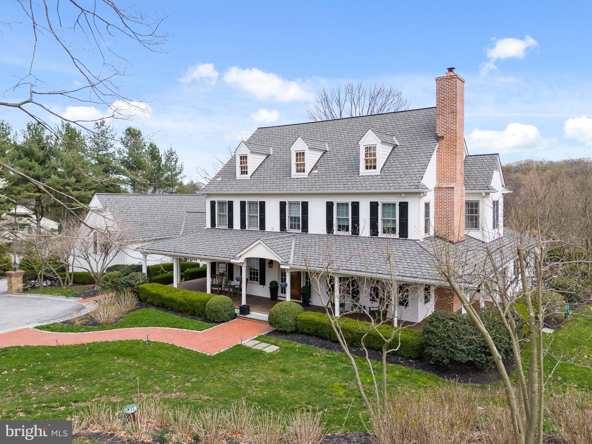 Welcome home to this magnificent custom-built estate, nestled on 3.20 picturesque, bucolic acres. This exceptional 5-bedroom, 5 full and 3 half-bath Colonial showcases timeless architecture, exquisite craftsmanship, and a thoughtfully designed floor plan ideal for both everyday living and elegant entertaining.  A grand Reception Hall welcomes you into the home, leading to a formal Living Room with a cozy gas fireplace, an elegant Dining Room with custom millwork, and a Butler's Pantry featuring granite countertops, sink, and cabinetry. The Kitchen offers granite countertops, stainless steel appliances, a Sub-Zero refrigerator, built-in desk, Breakfast Room, and a wall of windows overlooking the tranquil backyard. A door leads to the inviting screened porch.  The dramatic Family Room features soaring vaulted ceilings, a gas fireplace, a tray ceiling with cove lighting, and French doors to access the patio. The main level also includes a spacious Home Office, Sunroom, two Powder Rooms, and a Mud Room.  The luxurious Owner's Suite offers two outfitted walk-in closets, a Sitting Area with beautiful backyard views, and a spa-inspired bath with dual vanities, soaking tub, tiled shower, sauna, and private water closet. Two additional bedroom suites each feature outfitted closets and private baths, while the convenient Laundry Room includes a utility sink and storage cabinets.  The third floor offers another large bedroom, a versatile bonus room that can serve as a fifth bedroom or Family Room, and a full bath.  The finished lower level is designed for entertaining with a custom built-in bar, heated tile floors, cedar closet, storage room, powder room, and an impressive temperature-controlled Wine Room with humidor.  Connected by a breezeway is a private multi-generational suite, perfect for in-laws, guests, or an au pair. This self-contained living space includes a Living Room, Dining Room, full Kitchen, Bedroom, full Bath, and porcelain tile flooring throughout.  The professionally landscaped grounds create your own private retreat with a wraparound porch, brick walkways, an expansive flagstone patio with a stone fireplace, sparkling pool with waterfall, storage shed, mature trees, lush gardens, and fenced backyard.  Additional amenities include, updated lighting, newer HVAC systems, whole-house generator, extensive storage, neutral décor, no carpet throughout, video security, and easy access to major roadways.  This extraordinary estate offers luxury, privacy, and exceptional amenities inside and out. With too many upgrades to mention, this is a home that truly must be experienced in person. Schedule your private tour today!