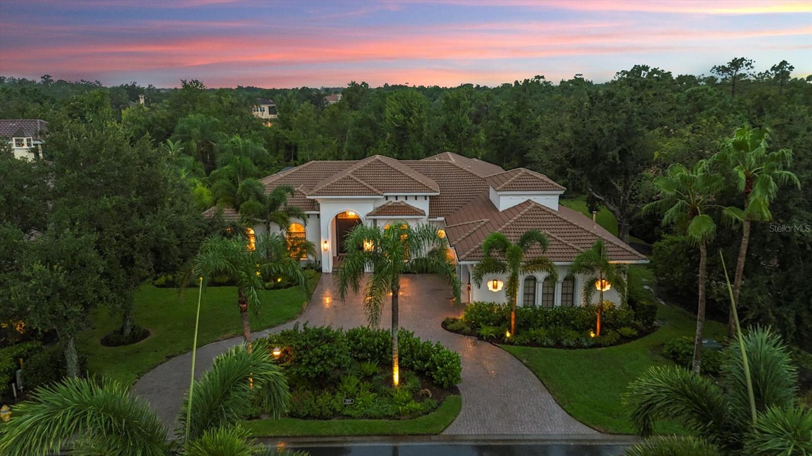 In Lakewood Ranch Country Club, this newly renovated, custom estate commands attention for its thoughtful floor plan, high-end selections and private preserve lot. As you arrive, note the quiet double cul-de-sac street, circular driveway and meticulously landscaped and fenced grounds. The double doors open to a grand foyer that leads to a light-filled sitting room with 10-foot glass sliders that extend the living space seamlessly onto the lanai for indoor/outdoor Florida living. Architectural details including 36-inch porcelain tiles, tray ceilings, crown moldings, custom window treatments, and new designer lighting and fans throughout create an atmosphere of understated sophistication. Continue towards the family room where you'll find a large modern yet elegant fireplace thoughtfully near the heart of the home, the warm, inviting kitchen. The kitchen doubles as an entertaining area with an oversized central quartz island. The dual oven Viking range and 60-inch custom plaster hood are showstoppers. The extra-large Rohl sink and faucet are just as functional as they are beautiful. The custom white oak open shelving lends an airiness to the space while a floor to ceiling built-in glass cabinet lets you showcase your heirlooms. The completely built-out pantry has pullout drawers for maximum utility and storage. A large corner coffee bar plus a dedicated wine room with dual wine fridges and ample shelving for your wine collection complete the space. The primary suite is thoughtfully on one side of the home. It is a private retreat that includes bay-window seating and access to the lanai. The fully renovated primary bath includes separate large individual Restoration Hardware vanities and elevated fixtures. The oversized stone Perlato soaking tub and expansive walk-in shower provide a spa-like experience. Not to be forgotten, note the newly built walk-in custom closets. In addition to two bedrooms that share a Jack and Jill bath, don't miss the gigantic bonus room with attached guest wing that includes a fourth bedroom, newly renovated bath and private gym/flex-space. Go out to the lanai to an expansive lounge area, to dine alfresco or for a dip in the pool. The new outdoor kitchen with built-in grill and hood, beverage refrigerator, sink and storage makes cooking outside easy. Further features include a spacious three-car garage with walk-up temperature-controlled loft storage, all-new outdoor lighting, and a fenced-in yard with a separate doggie run. This residence is complemented by its enviable location in the prestigious Lakewood Ranch Country Club, a gated community celebrated for its resort-style amenities and exceptional quality of life. Residents enjoy three championship golf courses, a state-of-the-art fitness center, tennis and pickleball courts and a grand clubhouse offering fine dining, social events and a vibrant lifestyle. With scenic walking trails, proximity to top-rated schools and easy access to Lakewood Ranch Main Street, Waterside Place, and the cultural treasures of Sarasota, this is more than a home—it is a complete lifestyle.
