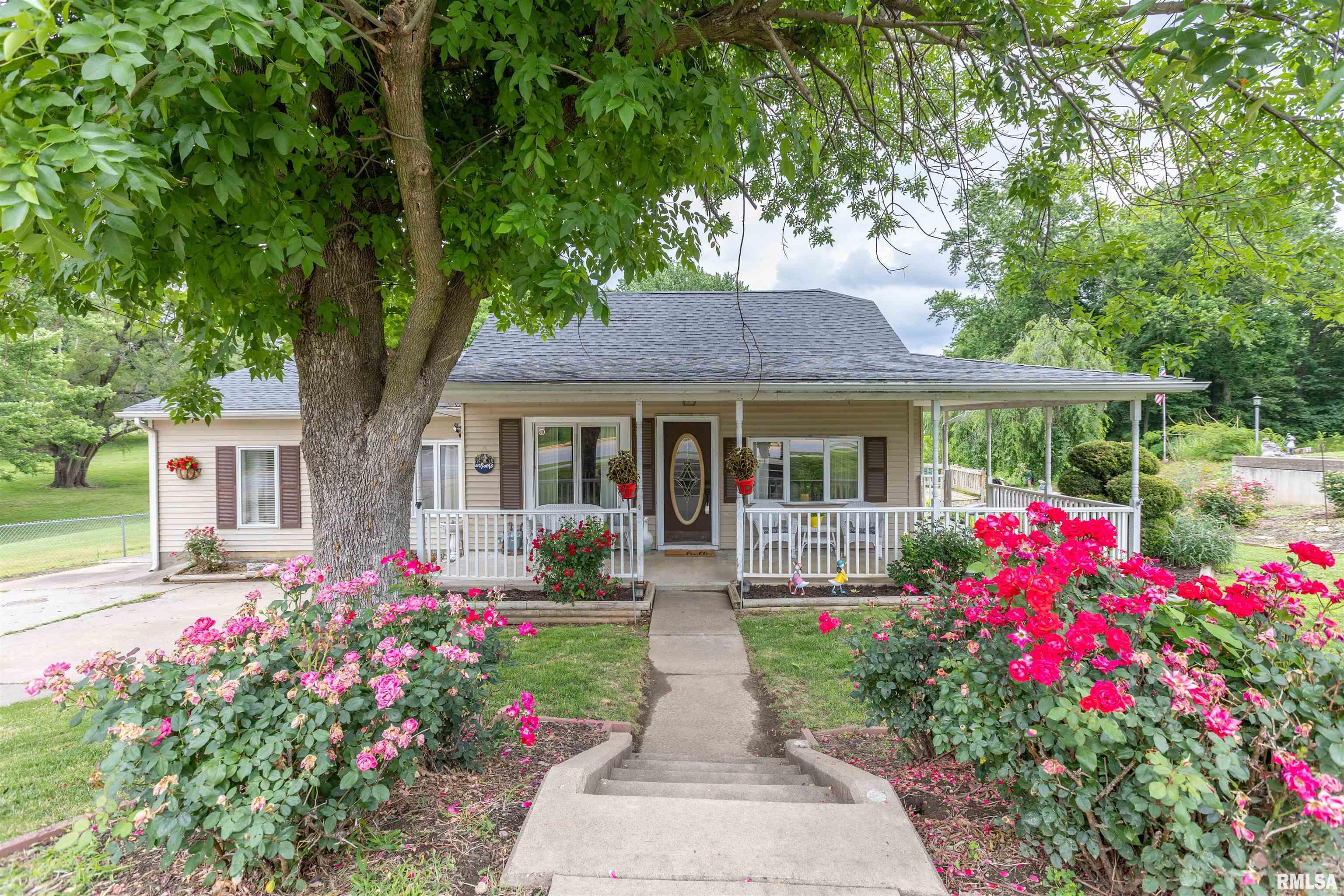 Pride of ownership shines throughout this well-maintained ranch home offering the convenience of main-level living and an inviting open floor plan. Numerous updates throughout the home create a move-in-ready feel while maintaining warmth and character. The spacious kitchen flows nicely into the living areas, making it ideal for everyday living and entertaining.  Step outside and enjoy the welcoming wrap-around front porch, beautifully accented by established landscaping and colorful flower beds that add curb appeal throughout the seasons. The oversized backyard provides plenty of room for outdoor activities, gardening, pets, or future improvements.  Additional features include a detached 2-car garage and a full basement offering excellent flexibility with a large family room area, half bath, and an abundance of storage space. The roof is approximately 5 years old, providing added peace of mind. A wonderful combination of space, updates, and pride of ownership make this property one you won't want to miss.