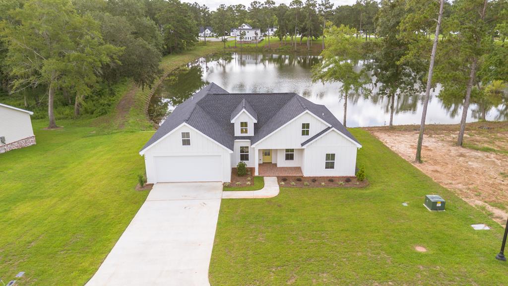 Your Dream Home on the Water Awaits at Bloomfield Lakes  Wake up to the sights and sounds of nature—ducks gliding across the lake, geese calling in the morning air, and serene water views right outside your door. This stunning new construction home makes that dream a reality, blending quality craftsmanship with a peaceful lifestyle.    With 2,750 square feet under roof (not including the oversized deck), this home was designed with the view in mind. Nearly every angle invites you to step outside, with walk-outs throughout the house leading to the back scenery. Inside, enjoy high ceilings, a spacious living room, and a gorgeous kitchen featuring White Pelican granite countertops, farmhouse finishes, and modern design details.    The primary suite offers a luxurious retreat with a well-appointed bathroom, walk-in closet, and direct connection to the laundry room for seamless daily living.    The highlight of this property is the oversized deck, built on a strong foundation and extending to the water's edge—perfect for morning coffee, evening sunsets, or entertaining with a view. The back covered porch, finished in classic herringbone brick, adds another elegant outdoor space to enjoy year-round.    Additional features include:  2-car garage with attic storage  Durable construction and thoughtful design throughout  Indoor spaces that flow naturally into the outdoors    Beyond your home, Bloomfield Lakes is more than just a neighborhood—it's a lifestyle. With winding pines, preserved natural beauty, and peaceful water views, this is Thomasville's first community fully equipped with fiber optic cable and 100% underground utilities, combining tranquility with modern convenience.    For more information or to schedule a private tour, call your favorite Realtor today.  Seller is a Licensed Broker, #340473.