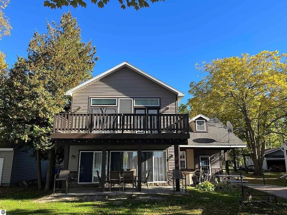 Welcome to lake life in beautiful Up North Michigan! This spacious home offers fantastic views of Cedar Lake with its open-concept kitchen, dining area, and great room - perfect for gathering with family and friends. The kitchen provides plenty of counter and cupboard space plus a pantry to keep everything well-stocked for summer cookouts and afternoon get-togethers. Designed with beach and lake activities in mind, the home features a large mudroom entry for easy transitions from outdoors to in. Upstairs, youll find four nicely sized bedrooms offering plenty of space and privacy, including a primary suite with a private bath. Step outside to enjoy lakefront living on the upper deck or relax on the main-level patios overlooking your own private frontage on Cedar Lake. A private dock makes it easy to head out for boating, fishing, or peaceful sunset cruises. Experience the best of Northern Michigan lake living - comfort, space, and incredible views all in one inviting package.