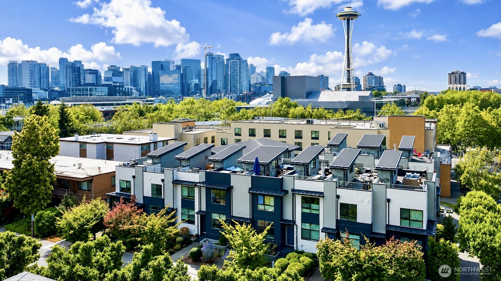 Sophisticated 4-Star Built Green townhome, built in 2016, in sought-after Uptown/Lower Queen Anne, just two blocks from Seattle Center. This freshly updated, move-in-ready 2-bedroom, 1.75-bath residence offers 1,294 sq ft of stylish urban living filled with abundant natural light. The open-concept main level features a beautifully appointed kitchen with quartz countertops, stainless steel appliances, solid wood cabinetry, and a gas cooktop. Fresh professional interior paint and new window blinds throughout create a crisp, polished feel. The expansive primary suite occupies the entire upper floor, offering a private retreat. The versatile lower-level flex space features new flooring, a 3/4 bath, and private patio, ideal for a home office, guest space, or additional living area. Enjoy exceptional indoor-outdoor living from the private rooftop deck with striking views of the Space Needle and Seattle skyline. A private attached garage provides secure parking and generous storage. Convenient to Seattle Center, Climate Pledge Arena, South Lake Union, dining, entertainment, and transit. No rental restriction.