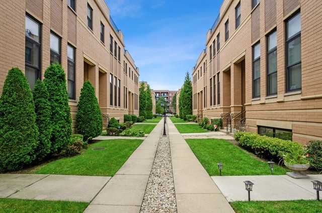 Expansive 3 Bed | 2.5BA all-brick townhouse with private rooftop deck and heated 2.5-car garage, offering 3,000+ sq ft across 4 levels in Portage Park/Dunning! Extra-wide 23' interior filled with natural sunlight. Dramatic 14' ceilings in the family room, plus an open formal living and dining area adjacent to a large kitchen with 42" cabinets, granite counters, island, pantry, and stainless steel appliances, along with a balcony and powder room. The spacious primary suite includes two walk-in closets and a spa-like bath with double vanity, whirlpool tub, and separate shower. Two additional bedrooms, a full bath, and laundry complete the same level. The top floor offers a versatile loft/den/bonus room with access to the private rooftop deck. Lower level features a large recreation room and abundant storage. HOA covers water, exterior maintenance, landscaping, and snow removal. Prime location near shops, dining, parks, Wright College, golf, groceries, transit, and highway access. Lives like a single-family home!