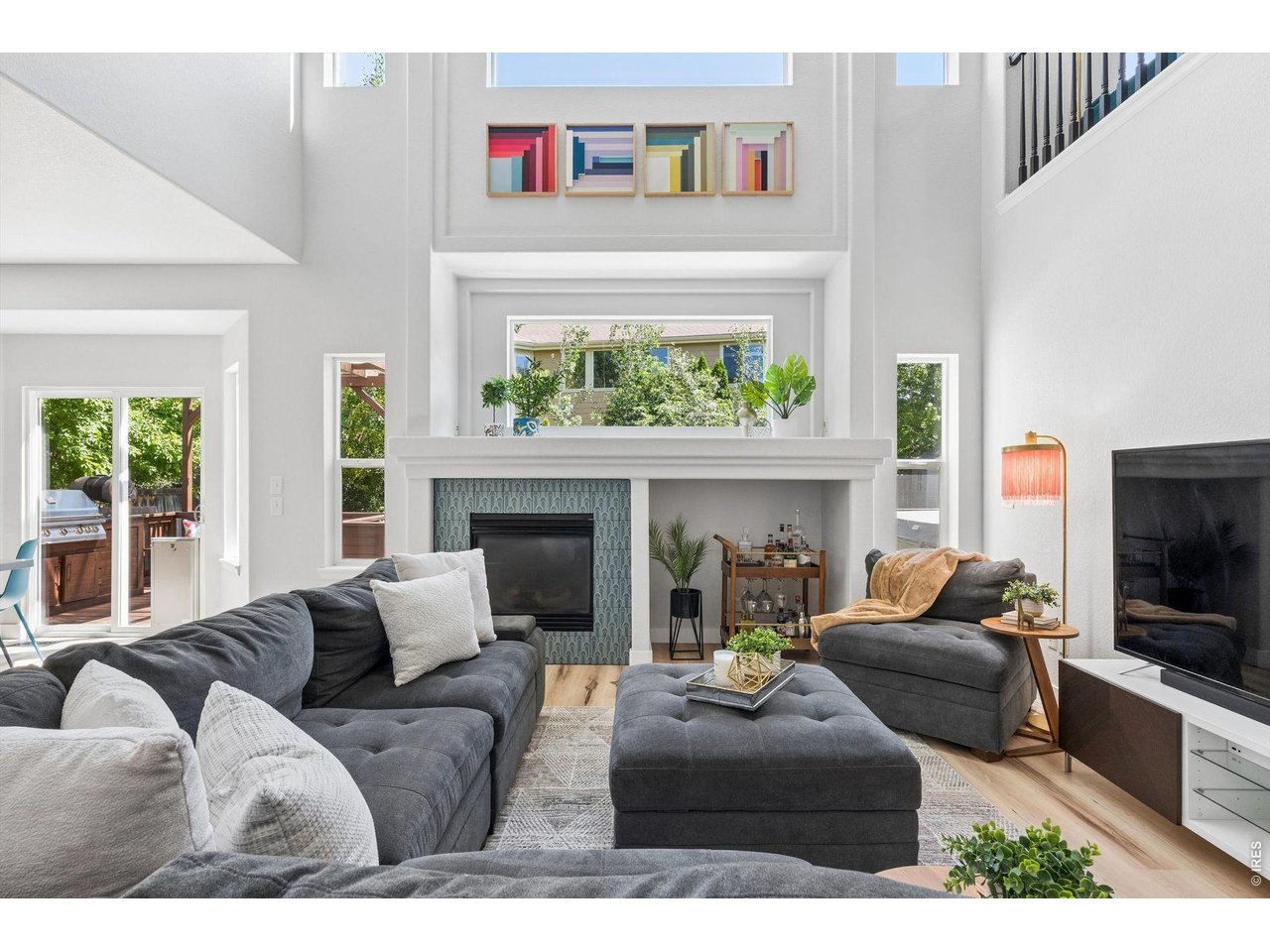 Tucked alongside open space and scenic trails, this thoughtfully updated 4-bedroom, 3-bath home pairs distinctive design with modern technology and flexible living spaces. Soaring ceilings, oversized windows and an open upper-level overlook fill the home with natural light, while curated finishes, upgraded lighting, black hardware & Art Deco-inspired details give the interior a style all its own. Formal living and dining provide room to gather and entertain, while the dramatic two-story living room centers around a gas fireplace with geometric tile. A private main-level office with French doors, recessed lighting and a smart Wi-Fi ceiling fan creates an ideal work-from-home retreat. The refreshed kitchen combines style and functionality with Carrara Breve quartz, a Delta workstation sink and LG SMART appliances, including a double-oven range with ProBake Convection, refrigerator with Craft Ice and ultra-quiet QuadWash dishwasher. Dual heating and cooling zones with smart thermostats add everyday comfort and convenience. Upstairs, plush carpeting leads to a spacious loft with custom built-ins, ideal for a library, media room or additional workspace. The primary suite offers a paneled accent wall, room-darkening shades and upgraded closet organization. The unfinished basement adds possibilities with carpeting, recessed lighting, natural light and plumbing roughed in for future finishing. The three-car garage is equally impressive with EV charging, smart garage access, a ceiling-mounted heater, high-voltage outlets, built-in workstations and storage. Outside, a pergola-covered kitchen with built-in JennAir grill and integrated seating creates a natural gathering place. A recently painted deck, mature privacy trees, raised garden beds, fenced yard and direct access to a paved neighborhood trail embrace the Colorado lifestyle. Extensively refreshed in 2023, this Fort Collins home brings together personality, thoughtful upgrades, connected technology and access to nature.