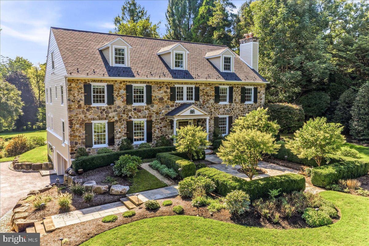 From the moment you turn down the long, private drive, it’s clear that this custom stone estate is in a class of its own. Situated on over an acre of meticulously manicured grounds, this three-and-a-half-story masterpiece blends classic architectural beauty with sophisticated spaces required for luxury living. The approach is nothing short of cinematic, featuring a stunning flagstone and brick walkway that leads through a lush front courtyard graced with extensive perennial beds. Inside, the grand three-story foyer sets a tone of timeless elegance, showcasing a wide staircase, rich black walnut finished hardwood floors with intricate inlays and bespoke woodwork that flows throughout the home. Designed for both entertaining and quiet moments of reflection, the main level has nine-foot ceilings and offers a seamless transition between the well-proportioned formal living and dining rooms. In addition, there are two gas fireplaces located in the living room and great room. The professional-grade gourmet kitchen is outfitted with a suite of Sub-Zero, Wolf, Thermador, and Bosch appliances. The kitchen flows into a sun-drenched breakfast room with a stunning coffered ceiling and an adjacent butler’s pantry, complete with a temperature-controlled wine closet. For those who work from home, the dedicated office features a full wall of custom cabinetry and shelving, providing a refined backdrop for any pursuit. The second floor is a sanctuary of comfort, anchored by an expansive landing with a built-in sitting area. The primary suite is a true retreat, boasting a dressing area, two walk-in closets (including one cedar-lined), and another built specifically to house shoes and handbags. There is a spa-like bathroom with heated marble floors and a deep soaking tub. Four additional generous bedrooms, each with an en-suite or shared bath with dual vanities, ensure that everyone has their own private space. The upper and lower levels continue to impress. The finished third floor offers vaulted ceilings, a large recreation area, multiple walk-in storage areas, and a bedroom that is currently used as a unique golf practice space. The finished lower level provides a secondary laundry and an additional full bath – great for guests. The outdoor living area is equally impressive. Three sets of French doors open to a sprawling rear patio, perfect for al fresco dining overlooking the flat, expansive backyard that is ready for a custom pool. With a brand-new exterior, a new generator, a 50-year roof and three-zoned HVAC; the home’s structural and mechanical integrity match its aesthetic beauty. Perfectly positioned for easy access to Center City, regional rail and the airport, this estate offers an unparalleled lifestyle for those who refuse to compromise on quality or location. Welcome home to "Grandview Manor,” a legacy property that is as functional as it is breathtaking.