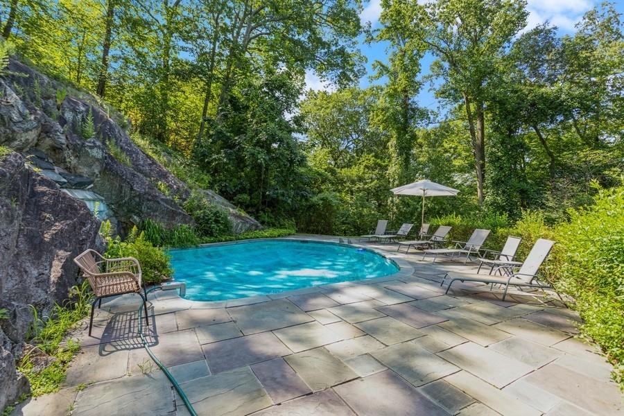 Experience the breathtaking serenity of this exclusive 2.5 acre private hilltop retreat boasting stunning mountain views. Step into the elegance of a gated Sands Mill brick Colonial that checks off every essential on your lifestyle wish list. Impeccable design and timeless style define this residence, accentuated by exquisite architectural details. The heart of this home is a chef's kitchen seamlessly connected to inviting areas, complemented by graceful formal rooms. Two primary suites offer luxurious escapes with newly renovated spa baths, while two additional ensuite bedrooms provide comfort and privacy. The expansive walk-out lower level features an extra guest suite and a three-car garage. Entertainment reaches new heights around the heated grotto pool, carved into a remarkable rock outcropping with a cascading waterfall and spa. This haven is just minutes away from Armonk Square, offering a plethora of amenities, including Main Street's dining and shopping, prestigious golf courses at the Summit and Whippoorwill Clubs, and upscale grocery shopping at DeCicco’s and Whole Foods. Stay fit with convenient access to Equinox or LifeTime Fitness. Nestled in an exclusive neighborhood, with Byram Hills Schools. Conveniently located near I-684, it's just a 15-minute drive to North White Plains Metro North Station, providing a quick 38-minute commute to Grand Central Terminal.