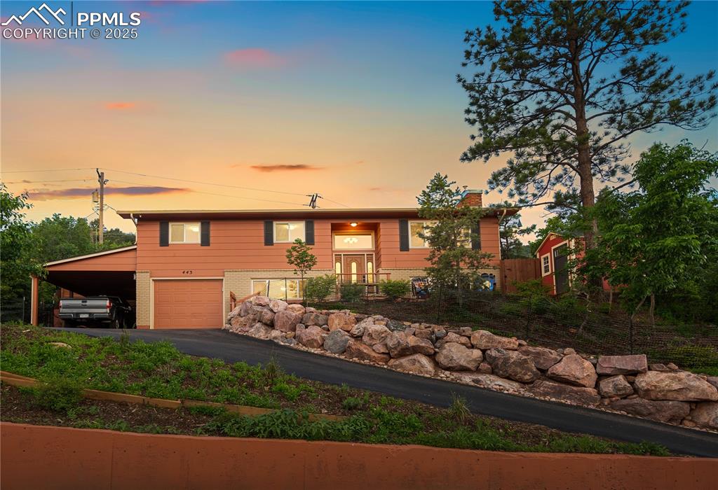 Stunning mid-century home in pristine condition! Located on a quiet street with expansive mountain views—including Pikes Peak—this beautifully updated Manitou Springs home offers peace, privacy, and modern comfort. Extensive upgrades from 2019 to 2024 include a full kitchen remodel with new cabinets, plumbing, flooring, backsplash, and premium appliances such as a Dacor oven, LG hood vented to the exterior, Maytag dishwasher, and updated outlets. Both upstairs bathrooms were fully remodeled, and the  interior of the home was completely repainted along with new blinds, drywall, insulation, and recessed lighting being installed. Electrical was updated from aluminum to copper and brought to code with a new panel and dedicated A/C wiring. Beautiful hardwood floors were added upstairs and on the staircase in 2024, and a new custom mantle was added to the freshly painted fireplace. Exterior improvements include a newer Class 4 shingle roof, full exterior paint, and professionally designed landscaping with irrigation, boulders, and deer fencing. The tranquil backyard features a stamped concrete patio, Cal-Spa hot tub, lush plantings, and a flagstone patio on the upper terrace of the yard with sweeping views of the mountains—ideal for relaxing or entertaining. The front and side yards were landscaped, and the asphalt driveway was widened and regraded in 2023 with boulder edging for curb appeal. Additional features include a garage, carport, shed, updated exterior faucets, and smart security with five cameras and a Ring doorbell. On top of all of this—it's just minutes from trails, parks, and downtown Manitou Springs. With stunning views, thoughtful upgrades, and a serene setting, this home is simply exceptional. This home has been Pre-Inspected!