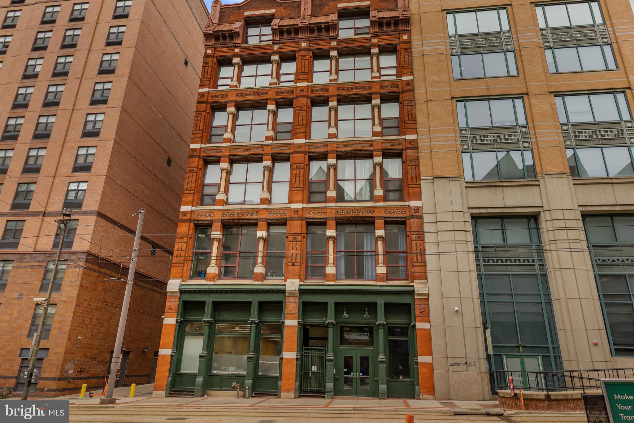 A rare Downtown Baltimore residence where historic architecture meets elevated city living. Set within a fully restored landmark building in the heart of the Bromo Arts & Entertainment District, this prime rear corner unit offers an exceptional blend of privacy, light, and timeless character. With southern and southwestern exposure, the home is filled with warm natural sunlight—and crowned by its signature feature: a grand arched window (the only one in the building) that frames a striking, uninterrupted view of the celebrated Bromo-Seltzer Tower (constructed in 1929).Inside, 12-foot ceilings amplify the sense of scale and openness while allowing lighting and design elements to shine. The living and dining areas feel expansive yet welcoming, enhanced by recent improvements: new oak laminate flooring (12/2025) throughout most of the home (excluding the 2nd bedroom/den), and refreshed surfaces in the living/dining room, including the ceiling and corner walls. The primary bedroom has been thoughtfully updated with new paint on the ceiling and two walls (8/2025) for a clean, modern finish.The residence comes with all appliances and key updates for comfort and confidence, including a 50-gallon professional-grade water heater (9/2021) and a new toilet (2022). The condo fee supports a streamlined lifestyle, covering heat and hot water, building common-area insurance and maintenance, and trash removal. Select extras are included: living/dining chandelier lights plus furnishings in the 2nd bedroom/den, including a king sleeper sofa, wardrobe, and 70” TV—a turnkey bonus for flexible living.From your front door, enjoy immediate access to Baltimore’s most dynamic destinations: Light Rail directly out front, Camden Yards, MARC station, Inner Harbor, Lexington Market, CFG Bank Arena, and the Hippodrome blocks away—plus effortless connectivity to I-395, I-95, and MD 295. Distinctive, sunlit, and truly one-of-one—schedule your private tour today.