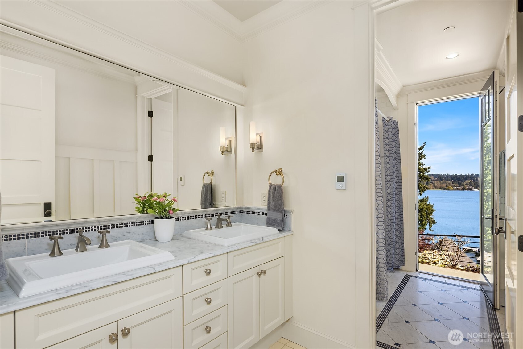 Another beautifully appointed full bathroom where marble slab counters and classic tile patterns bring timeless character to the space.