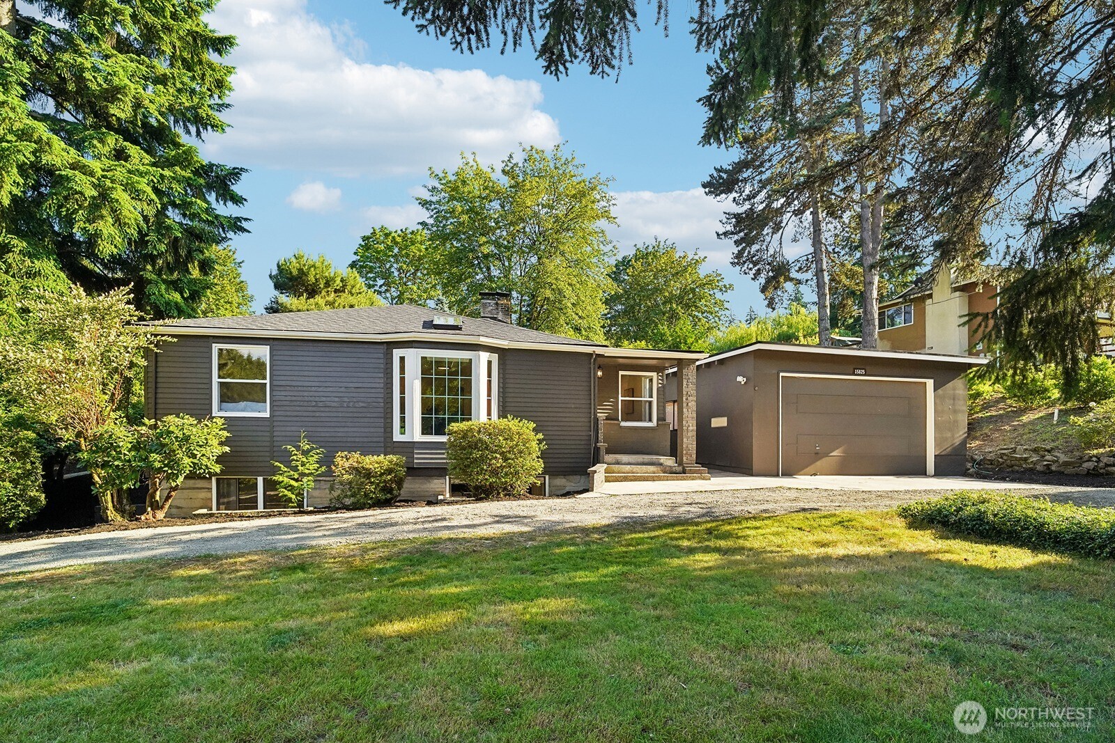 Modern farmhouse style meets private acreage living in this fully remodeled home set on a peaceful 1-acre lot. A circular driveway, RV parking, new roof, and an impressive 22x50 workshop/garage add exceptional flexibility, while the bright open floor plan, skylights, picture window, and stylish updates create a warm, move-in-ready feel throughout. The remodeled kitchen features stainless steel appliances, tile backsplash, updated cabinetry, and easy flow into the main living and dining areas. Fresh interior and exterior paint, new LVP flooring, new carpet, new trim, and updated doors give the home a clean, cohesive look. The updated bathrooms continue the modern feel with refreshed finishes throughout. Downstairs, the daylight basement offers an enormous bonus room with a walk-out slider, creating excellent space for a media room, rec room, home office, gym, or guest space. Multiple storage areas provide added function, while the two-tier deck extends the living space outdoors and overlooks the private lot. Ideally located between Issaquah and Renton with access to the coveted Issaquah School District, this property offers comfort, versatility, and room to enjoy a more private lifestyle.