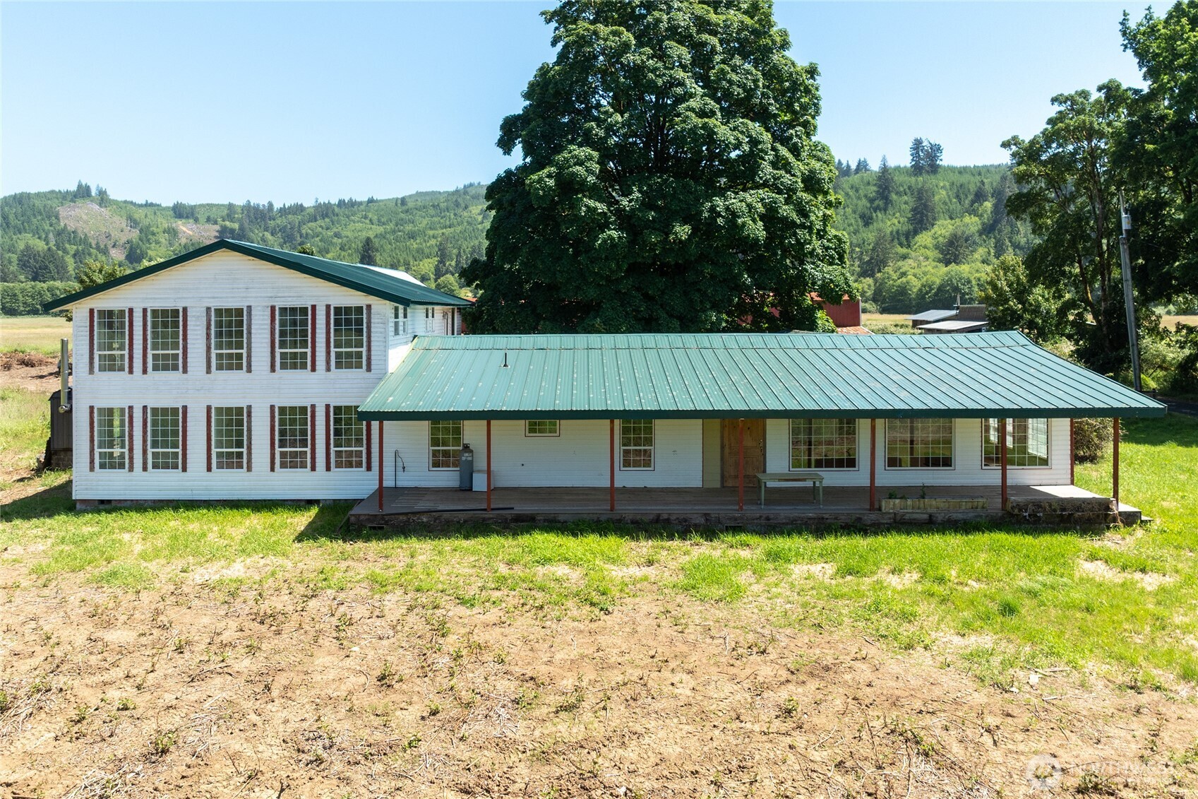 Opportunity, space, and potential come together on this remarkable 5-acre property in the heart of Grays River. Located just beyond the area's iconic covered bridge, this 6,080 sq ft property offers incredible flexibility for a spacious residence, retreat, lodge, multi-generational living, or other permitted uses.    Inside, you'll find expansive living spaces, including a large living room, family room, beautifully remodeled kitchen, new flooring, 7 rooms, and 3 bathrooms. Outside, enjoy territorial views from the huge front deck, along with mature trees, a nearby pond, stone patio, barn, outbuildings, and abundant parking.    With a metal roof, public water, private septic, and plenty of room to grow, this property offers tremendous upside for a buyer with vision. Surrounded by natural beauty and the charm of historic Grays River, this is a rare opportunity to own a property with exceptional space and potential.