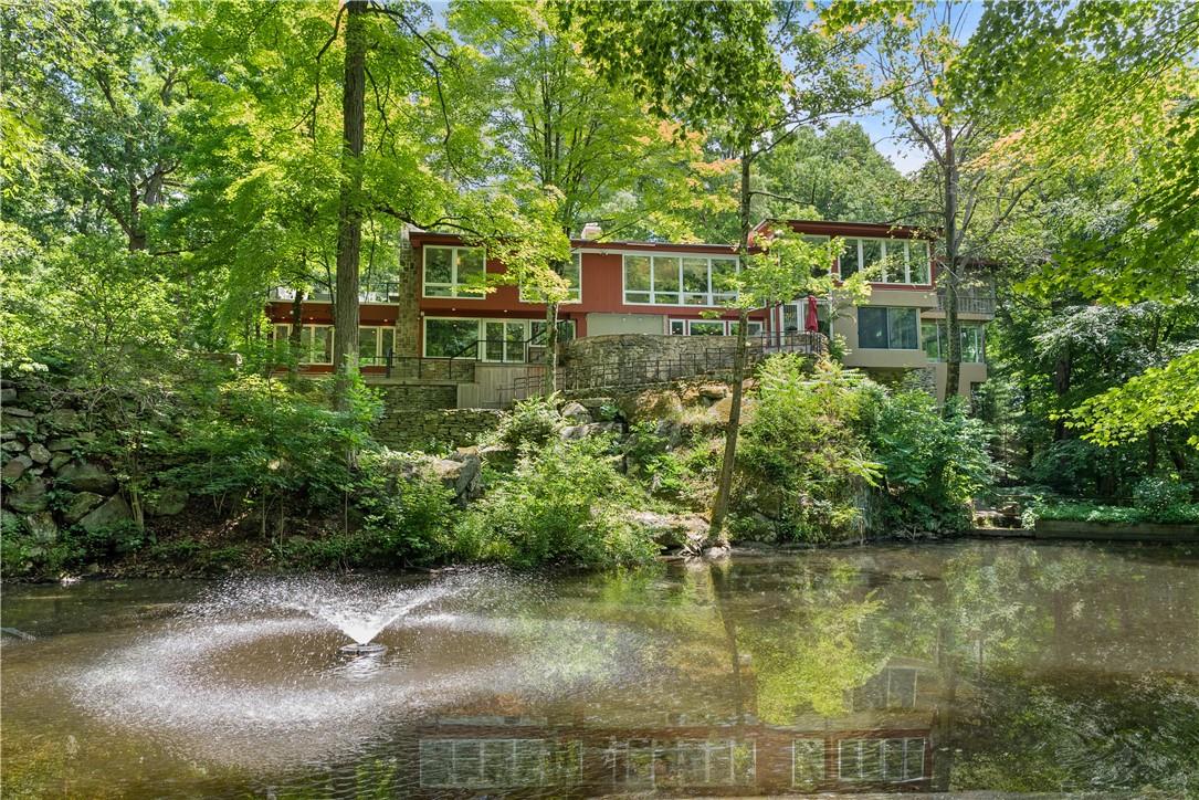 Discover the epitome of tranquility in this newly renovated mid-century home, a masterpiece thoughtfully designed by a renowned landscape architect. Nestled on nearly 2 acres of breathtaking property, this nature lover's paradise offers endless opportunities to relish the great outdoors. Surrounded by lush trees, a nature preserve, and a golf course, this home is your private sanctuary. Enjoy the custom stone pool, three serene ponds, and multiple stone terraces, one featuring a hot tub, outdoor TV, and fireplace. Immerse yourself in the natural plantings and meticulously designed gardens. Despite its serene ambiance, this retreat is just a 38-minute express train ride to NYC, offering the perfect blend of seclusion and urban accessibility. The newly renovated interior boasts 4 spacious bedrooms and 3 luxurious spa bathrooms. The primary bath is a sanctuary in itself, featuring a custom shower with natural stone, a sauna, and a fireplace, as well as a large dressing room and closet. Modern floor-to-ceiling windows throughout the home invite in an abundance of natural light and showcase the stunning surroundings. An incredible screened-in living room porch seamlessly blends luxurious comfort with the breathtaking beauty of nature. Come and experience this serene retreat – a perfect harmony of modern luxury and natural splendor. Additional Information:  Amenities:Dressing Area,Soaking Tub,Storage,