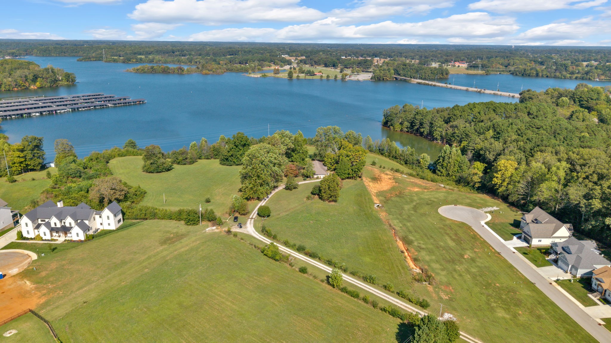 Welcome to the picturesque shores of Tims Ford Lake, in Franklin County! Nestled on a 2.3 acre lot, this property features a 4-bedroom, 2-bath home and offers a RARE opportunity to own a slice of paradise in Winchester, Tennessee. No subdivision, No HOAs, but right in the heart of Winchester! Breathtaking views with nearby access (Twin Creeks Marina)to one of the area’s most sought-after lakes! The property offers stunning views of Tims Ford Lake, where you can enjoy beautiful sunsets and a shaded expansive lawn with plenty of room for outdoor activities! Spectacular views of July 4th fireworks from Winchester City Park right from your backyard! With the option to purchase a boat slip at Twin Creeks Marina, your lake adventures are just a stone's throw away. Leisurely days on the water are just a golf cart ride to the marina from your new home. Step inside to discover 8-foot ceilings throughout, over 5-foot wide hallway leading you to 4 generously sized bedrooms, 2 baths, providing ample space for family & guests. The kitchen is 12x26 and the living room/dining room is 18x29 with ample room for expansion and remodeling. The earthen basement, accessible from both the kitchen through a stairwell and directly from the outside via a garage door, offers incredible potential to make it into a game room, extra living space, or additional storage, and could be finished to suit your needs. The property features a covered 12x30 structure, ideal for outdoor entertainment creating the perfect environment for gatherings with family and friends. Enjoy the freedom of living within city limits without the constraints of an HOA, as this charming property is not part of Twin Creeks Village. Located just minutes from downtown Winchester, enjoy a community filled with dining, shopping, and local attractions. This home is perfect for your primary residence or as a weekend retreat, Airbnb, bed and breakfast, or countless other possibilities.