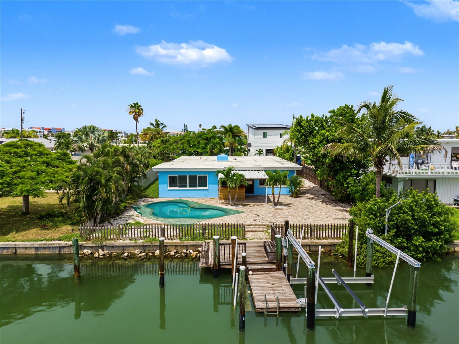 BEACH, BOATING OR POOL?  WHY CHOOSE WHEN YOU CAN HAVE ALL THREE!  WELCOME TO YOUR PRIVATE WATERFRONT ESCAPE ON ISLAND ESTATES!  Situated on a cul-de-sac street, this exceptional coastal retreat has been renovated from top to bottom.  Start your morning with your favorite beverage overlooking the water, or step onto your private dock equipped with a 10,000 lb. boat lift with NEW GEM REMOTES CONTROL BOX and set off for a quick ride to the Gulf!  Spend the day cruising to sandbars, fishing the Gulf waters, or stopping at your favorite waterfront restaurant.   Step inside your new home to a bright, open-concept floor plan featuring crown molding, shiplap ceilings, a skylight that brings abundant natural light into the living room, energy-efficient windows, plank-style tile flooring, and a wood-burning fireplace that adds warmth on those rare cooler evenings.  The impressive kitchen showcases rich navy-blue cabinetry, sleek quartz countertops, a deep basin sink, elegant gold faucet and hardware, NEW stainless steel range, dishwasher, and microwave, a closet pantry, breakfast bar with pendant lighting, plus there’s additional cabinet storage in the oversized laundry room.  Designed with privacy in mind, the split-bedroom layout places the primary suite with ensuite bath and the second bedroom and guest bath on one side of the home.  Both bathrooms have been tastefully remodeled with a fresh, coastal-inspired design. The third bedroom overlooks the pool and water and a generous bonus room offers even more flexibility for a media room, game room, fitness area, hobby space, or whatever best complements your lifestyle.  Additional highlights include a 5-unit mini-split A/C system, NEWER modified bitumen roof installed in 2023, NEW water heater in 2025, NEW pool pump motor installed August 2026, pavered driveway, converted garage ideal for storage or golf cart parking, plus an additional exterior storage room.   Surrounded by mature tropical landscaping, the fenced backyard was created for relaxation, entertaining and making the most of Florida’s sunshine.  Lounge on the sun shelf of the sparkling inground pool, gather with friends and family at the covered outdoor bar, or get cozy in your favorite chair on the expansive pavered patio and enjoy tranquil water views.  This Island Estates location is hard to beat! Take a quick 5-minute walk to the area’s sugar-sand beaches, or explore nearby boutiques, restaurants, local pubs, and live entertainment.  Hop on a golf cart, stroll, or ride your bike and enjoy an easygoing way to experience everything the area has to offer.  Nearby attractions include fishing charters and ROC Park, featuring pickleball courts, outdoor events, and concerts, along with the famous John’s Pass Village & Boardwalk, where shops, dining, watersport rentals, music, and activities provide something for everyone.  St. Pete-Clearwater International Airport is approximately 30 minutes away, while Tampa International Airport is about a 40-minute drive.  Whether you're heading out for an early-morning boat ride to the sandbars, enjoying waterside dining or a sunset cruise, fishing the Gulf, spending the afternoon at the beach, or gathering poolside under the stars, this remarkable property puts the Florida waterfront lifestyle right outside your door.  Discover a place where beach, boating, pool days, laid back living and Island charm come together to create an extraordinary place to call HOME!
