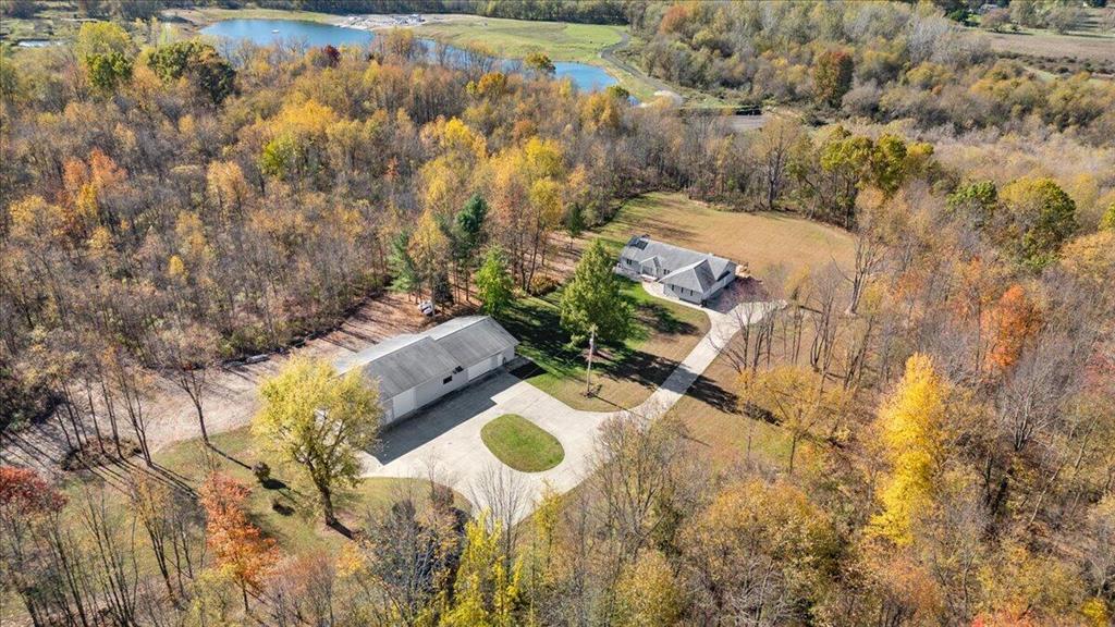 This beautiful, custom-built executive ranch sits atop nine secluded, densely wooded acres, offering exceptional privacy and natural beauty. The home features a spacious main-floor primary suite with an en-suite bath, large walk-in closets, a marble shower, and a relaxing whirlpool tub. An open floor plan with cathedral ceilings enhances the sense of space, while EnergyStar efficiency ensures comfort and performance throughout.  The fully finished walkout lower level provides additional living space with a cozy rec room and fireplace, two generous bedrooms, and a full bath--perfect for guests or family.A true highlight of this property is the impressive nearly 4,000 sq. ft. pole barn. Designed for versatility, it includes two separate heated spaces, two 14' access doors on one side, and a 2.5-car access door on the other. The building is also plumbed for a full bath and offers the potential to include a kitchen--ideal for a workshop, hobby space, or business use.
