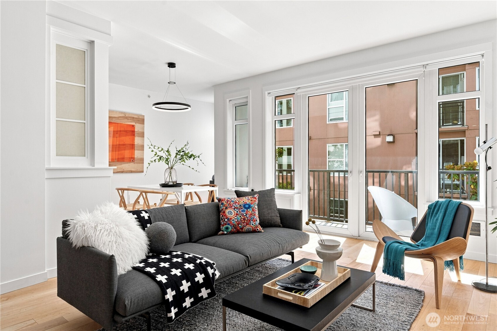 Refreshed price and move-in ready!! Welcome to the Vine's largest 1BD + Office/Den floor plan. Scandinavian modern-inspired design and exceptional craftsmanship define this beautiful, architect remodeled residence offering 969 square feet, 1BD, 1.5BA, plus a versatile office that easily functions as a work and/or guest space.     Warm maple hardwood floors flow throughout, complemented by Brazilian slate tile in the primary bath. The sophisticated kitchen showcases quartz countertops, Bosch appliances, a counter-depth Fisher & Paykel refrigerator. Matte black fixtures create a cohesive, contemporary aesthetic carried throughout. Additionally, premium Sonneman lighting, touch-activated faucets and custom mirrors add to the curated feel.    French doors open to a private balcony overlooking the beautifully landscaped garden courtyard, creating a peaceful retreat in the heart of the city. Mini-split air conditioning, a secure garage parking space, and a private storage locker add comfort and convenience.    Residents enjoy beautifully maintained common areas and one of Belltown’s finest rooftop decks, offering sweeping 180-degree views of Puget Sound, Elliott Bay, the Olympic Mountains, and spectacular sunsets.    Just moments from Pike Place Market, the waterfront, Olympic Sculpture Park, restaurants, coffee shops, and downtown employers, this turnkey home offers an exceptional blend of sophisticated design, flexible living space, and an unbeatable urban lifestyle.