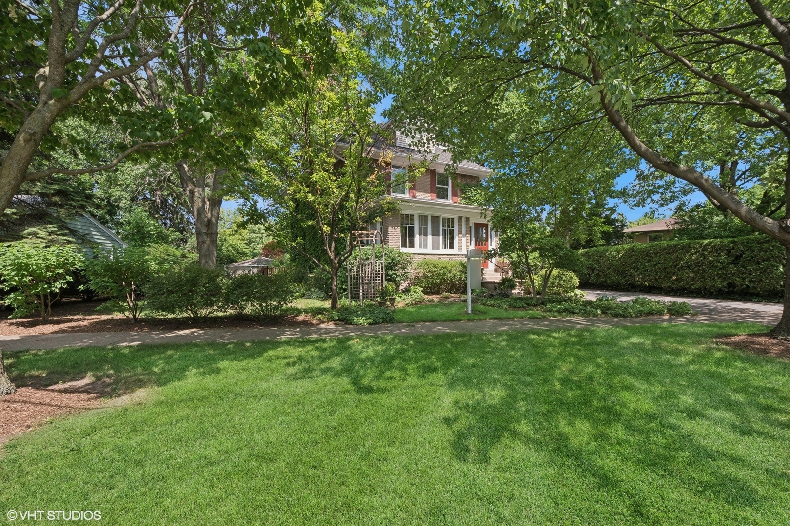 This beautiful, four bedroom, two and a half bath home welcomes you as you enter the enchanting front enclosed porch, perfect for morning coffee or an evening gathering with friends. The living room and dining room invites the outside in with natural sunlight and garden views. The updated eat in kitchen and family room with stunning corner brick fireplace are ideal for entertaining. And, the beauty of this home extends to the charming main floor bath! Hardwood floors throughout. The second floor boasts a terrific laundry room with a sink and lots of storage. Three nice size bedrooms with new carpet and a full spacious bathroom. The nursery or office leads to the third floor fourth bedroom en suite with skylight, built-ins, walk-in closets, and updated bath with spacious step shower. Lots of additional living space in the above ground English basement that boasts a recreational room, a half bath, a bedroom, an office and storage. Outdoor living offers a deck and patio to take in the lovely perennial gardens. There is an attached garage with ample driveway parking. Wonderful location, close to Wilmette Park Districts Centennial pool, tennis courts and ice skating rink. Beautiful Lovelace park and desirable district 39 schools.