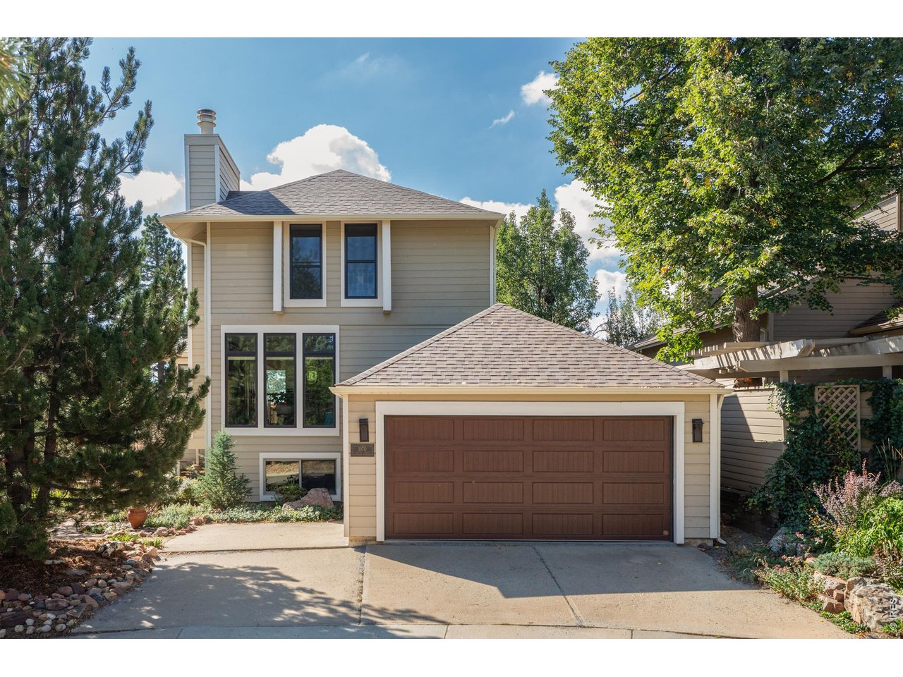 Backing directly to Boulder County Open Space at the end of a quiet cul-de-sac in Shanahan Ridge, this updated 4 bedroom, 4 bathroom home offers 3,140 square feet with the Lehigh Connector Trailhead at the property line. The NCAR trail system and the approach to Bear Peak begin just beyond the fence, so hikes and trail runs start at your back door, and mountain views make nature part of everyday life. Inside, a sunken living room features a wood-burning fireplace and oversized windows, flowing into a kitchen with granite countertops, shaker cabinetry, an island with bar seating, and a wood-paneled, skylit ceiling. The kitchen opens to the family room, where soaring A-frame windows frame Open Space views toward Eldorado Springs. Hardwood floors and a built-in bar buffet carry into the dining room, and sliding doors from both the dining room and family room open to the patio for easy indoor-outdoor living. Upstairs, the primary suite includes a wood-beam ceiling, a wide slider to a private balcony over the open space, and a remodeled bathroom with a walk-in closet, separate soaking tub, double-sink granite vanity, and large shower. Two additional bedrooms share a full bathroom. The lower level is a full height daylight level with substantial natural light and functional living spaces. It includes a recreation room, a private bedroom, a three-quarter bathroom, a large laundry room, and a vapor-barriered storage area. An oversized mudroom off the attached two-car garage adds a separate refrigerator, custom cabinetry, and vaulted ceilings, with additional driveway parking. Every window and door has been replaced for added comfort and efficiency. Outside, a low-maintenance backyard offers a deck, a stone patio, and a stone path straight to the trailhead. Shanahan Ridge has a community pool, Harlow Platts Community Park, and neighborhood parks, all minutes from South Boulder dining, shopping, and everyday conveniences.