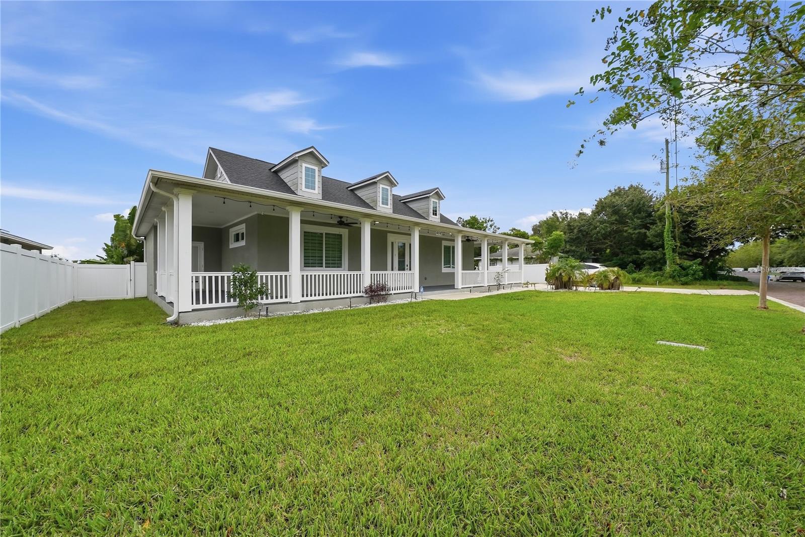 Rarely available and built to impress, this 2022 brand-new construction single-family residence in Largo sits on an expansive double lot in a high-and-dry Non-Flood Zone. Highlighting over $50,000 in recent upgrades, the modern interior showcases a designer entertainment space with high-gloss checkered tile flooring alongside polished large-format porcelain tile. A custom statement feature wall boasts illuminated acoustic wood slat panels with integrated LED lighting framing a large-format Calacatta porcelain marble slab accent wall. Designed for lifestyle and adaptability, the layout includes flexible living space alongside a detached garage with incredible potential for a home office, private gym, or workshop. The outdoor footprint is an absolute entertainer paradise, boasting a classic 1,100 square foot wraparound front porch ideal for relaxing in rocking chairs while watching kids play, plus a covered rear porch overlooking a saltwater pool with custom paver decking perfect for weekend grilling and poolside gatherings. Nestled in a prime central Pinellas location, you are just a 10-minute walk to the new Downtown Largo City Hall complex with local dining and shopping, minutes to iconic Largo Central Park, a 10-minute drive to the Belleair Causeway, and only 20 minutes to Gulf Coast beaches. Properties offering this 2022 new construction quality, architectural charm, luxury finishes, double lot size, and location do not come along often and will not last long.