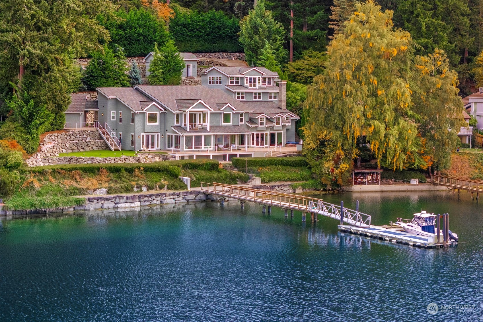Legacy Waterfront home w/ deep water DOCK in Gig Harbor; 1+ acre western exposure w/ +/- 150’ Low-bank waterfront to easily hold a 70’ BOAT. 2015 Interior/exterior remodel by Harrison Homes to create a 12,990 sq ft Luxuriously finished waterside estate. Chef’s ENTERTAINING KITCHEN w/ 6-person island; high end Wolf; Liebherr; Kegerator; drop down media screen in attached family room. 5 Bedroom Suites-Zoned for 7; 1 ON MAIN; Primary w/ deck overlooking waterfront, 2 walk ins; marble double shower. 2 UTILITY rooms, Elevator, Entertaining areas flow to outdoors: two firepits w/ outdoor speakers. 1200 Bottle WINE Storage; DETACH BLDG w/ Full Swing GOLF Simulator. SPORTS Court-Control 4 Smart Home. 5 CAR GARAGE & car CAROUSEL. A true LEGACY home.