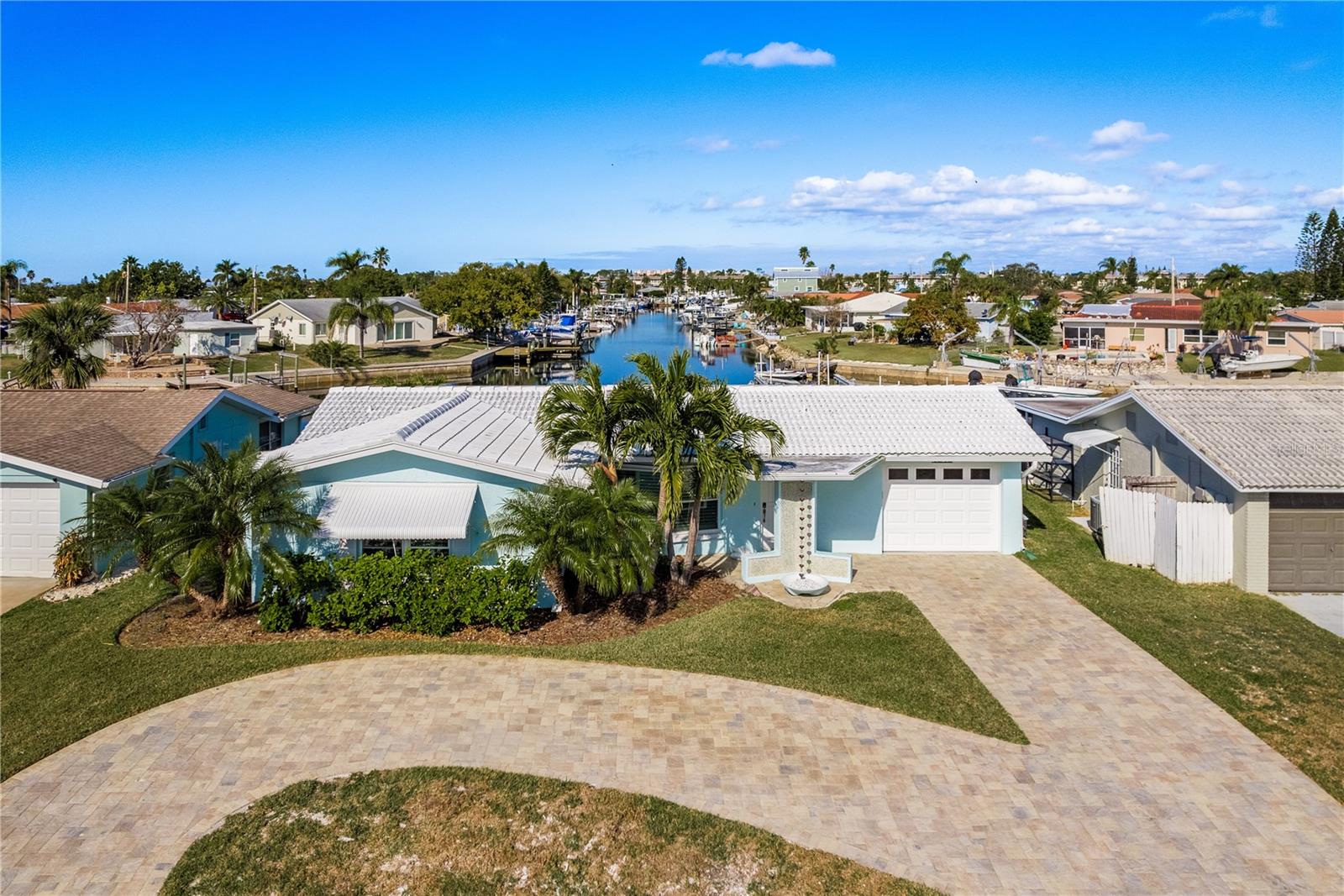 Come enjoy the Tropical Lifestyle in this newly renovated 3-bedroom, 2-bath home featuring 66 feet of waterfrontage with 10,000 lb. lift, huge 24 x 24 fixed dock with composite decking, convenient catwalk on the side of the lift, and brand-new floating dock. Situated on the deep sailboat-friendly South Channel with quick, easy, direct and unobstructed access to the open Gulf waters! Located in the highly sought-after community of Gulf Harbors. This home offers a great 3-way split-floor plan boasting a spacious living room with built in electric fireplace.  The kitchen features solid wood cabinets, quartz countertops, stainless steel appliances, built-in desk area and large breakfast bar serving into the family room. The large family room features hurricane-grade sliding doors leading out to the large Travertine paver deck and offers beautiful and expansive water views. Off one end of the family room is the large primary suite which also offers wonderful water views, sitting/office area, huge walk-in closet and private primary bath with step-in shower. Off the other end of the family room is one of the 2 guest bedrooms with water views and its own access to the garage.  The other guest bedroom located in the front of the home is gracious in size and has a large walk-in closet. Both guest bedrooms are served by a full guest bathroom. The home offers Travertine tile and Plantation Shutters throughout. The huge Travertine paver deck in the backyard is a perfect place to entertain your envious guests and enjoy the cool gulf breezes and has a built-in gas fire pit! The large paver circular drive allows for plenty of parking. This home has been completely replumbed, new electrical throughout, all drywall has been replaced from top to bottom. New HVAC system, duct work approximately 5 years old. This home is ready for you & your boat(s) to start enjoying the sandy beaches of nearby tropical islands! Excellent fishing, diving, water sports, shelling, island exploring, and more all right outside your door! Gulf Harbors is a golf cart friendly community and has an optional association that offers 2 boat ramps & other amenities. You also have the option to join the Gulf Harbors members-only private sandy beach overlooking the beautiful Gulf and Anclote Key offering cabanas & grills. Downtown New Port Richey, just a short drive away is lively and quaint with many restaurants, bars, shops, and Sims Park where you can enjoy one of the many special events and outdoor concerts throughout the year or stroll along the beautiful riverwalk along the Cottee River. Schedule your viewing today!