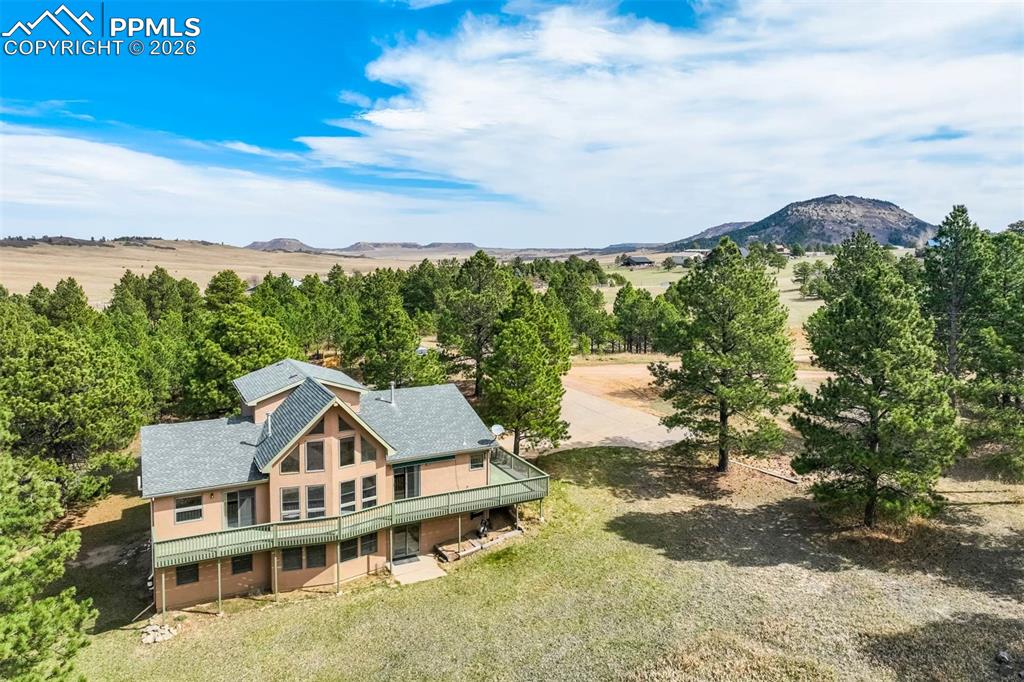 Set on five beautiful acres with mountain views, open meadows, and mature trees, this 4-bedroom, 4-bath home offers the rare combination of privacy, space, and horse-friendly living. Zoned for horses, the property provides endless opportunities to enjoy country living just minutes from Monument.Inside, the home has been lovingly maintained and offers a spacious, functional floor plan filled with natural light. Vaulted ceilings and expansive windows frame the surrounding views, while the large deck creates the perfect place to take in the mountains and peaceful setting.The main level features a spacious primary suite with a five-piece bath, plus a second bedroom ideal for guests. The loft overlooks the great room below and includes built-in shelving and a convenient half bath—perfect for a study, library, or creative space.The walkout basement expands the living area with two additional bedrooms, a full bath, and a large family room that opens directly to the backyard. A 2-car garage and five-acre setting complete this exceptional Monument property.