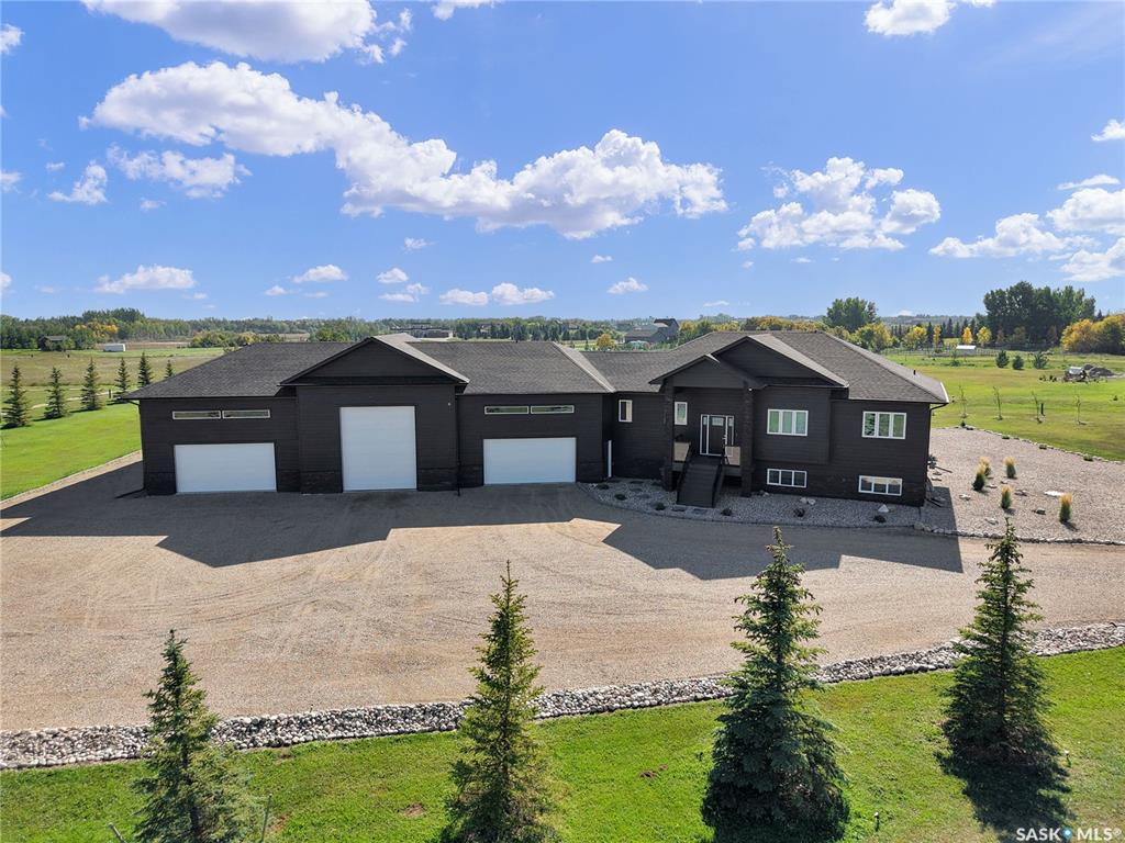 Welcome to this exceptional custom-built estate, a rare combination of sophistication, comfort, and modern design. Strategically located within the exclusive Grasswood Estates, this property provides the epitome of luxury lifestyle both in and out. Walk in and find yourself in a considerate floor plan with 12mm waterproof laminate flooring throughout, in-floor heat in the basement, and central air for warmth all year round. The gourmet kitchen boasts a natural gas hookup, waterfall island, microwave/oven combination, and streamlined finishes to create a fashionable and efficient space. Live outdoors on the front and rear composite decks, including a covered deck perfect for year-round entertaining. The beautifully landscaped yard boasts an irrigation system with a well that provides water only for the irrigation system (drip irrigation system), crushed rock landscaping, and more than 100 mature trees for shade, privacy, and serenity. Relax in the spa-inspired bathroom with a 12-inch rain shower, or withdraw to the huge 2400SQFT heated garage with a 20-foot interior room, ideal for truck parking or 10 vehicles or workshop layout with industrial ceiling fans, industrial heaters and industrial led lights. Among these are natural gas BBQ hookup, high-end construction, and an unmatched combination of luxury and usability. Whether entertaining guests or simply soaking up peaceful prairie sunsets, this rare property was crafted to awe. Enjoy the finest combination of estate living and contemporary convenience - only minutes from Saskatoon. Buyer and Buyer's agent to verify measurements. Please don't hesitate to call me or your favourite realtor to book a showing.