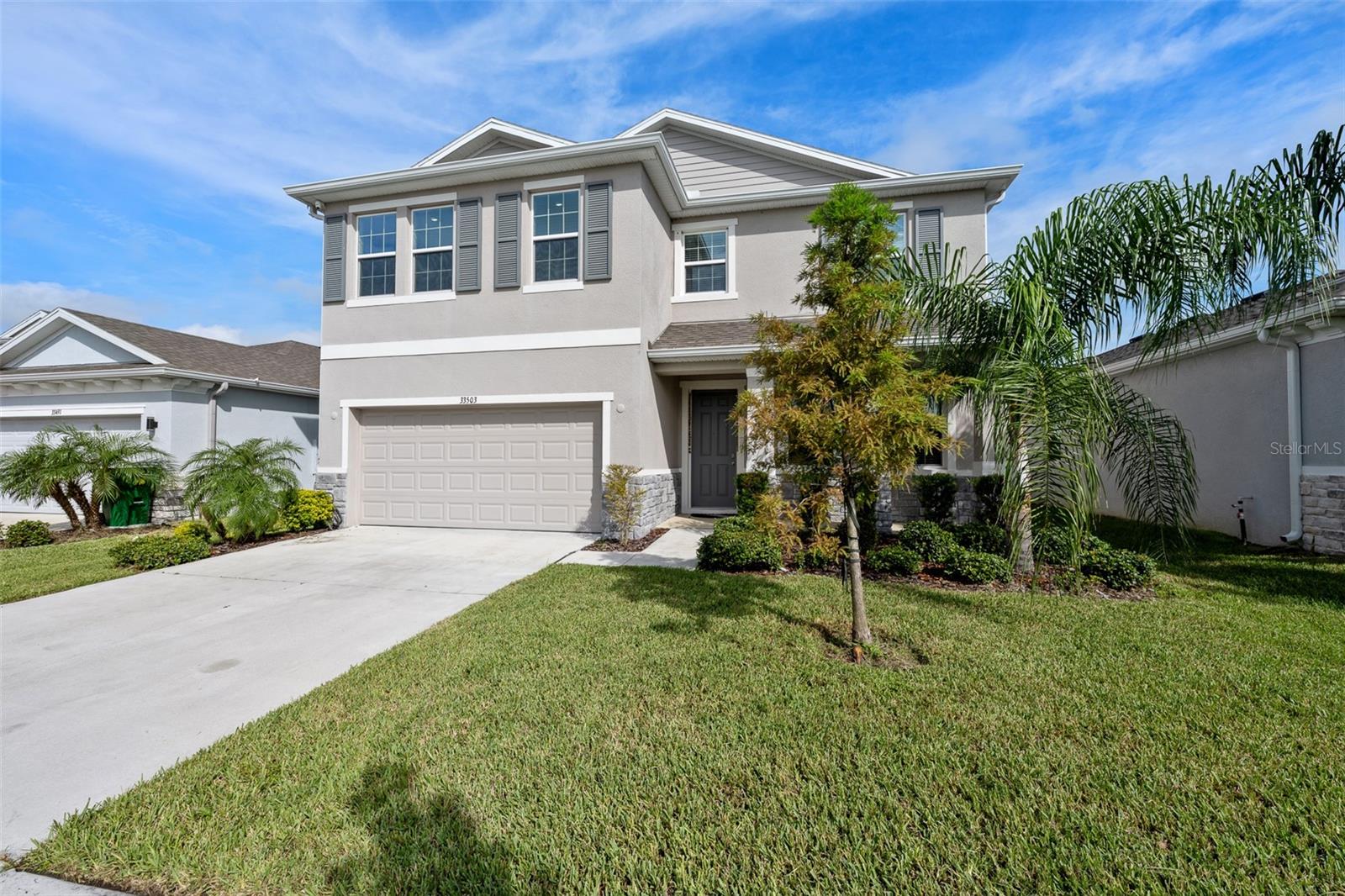 Beautifully 2023-built home offering a spacious, versatile floor plan with 4 bedrooms, 3 full bathrooms, and a peaceful pond view. From the impressive 8-foot front door, you’ll enter a bright, open-concept main level featuring tile flooring throughout the first floor and a seamless flow between the living and dining areas. The well-appointed kitchen features granite countertops, a large center island, solid-wood shaker cabinetry, an oversized pantry, and an upgraded premium Samsung refrigerator. A conveniently located first-floor office with French doors featuring glass inserts provides the perfect space for working from home or creating a private study. The main level also includes a spacious bedroom and full bathroom with a walk-in shower, ideal for guests or multigenerational living. Upstairs, you'll find an oversized loft offering exceptional flexibility for a media room, playroom, home gym, or additional living space, along with two generously sized bedrooms. The expansive primary suite provides a relaxing retreat with two walk-in closets and a luxurious en-suite bathroom featuring an extended granite vanity, a deep soaking tub, tiled walk-in shower with glass enclosure, and separate water closet. Enjoy easy outdoor living with sliding glass doors leading to the covered patio and a large, fully fenced backyard overlooking the pond. Additional features include a Qolsys IQ Panel 4 security system and a 2 car garage pre-plumbed for a future water softener system. Ideally located in sought-after Wesley Chapel, this home offers convenient access to an abundance of shopping, dining, entertainment, recreation, and family-friendly amenities, including The Shops at Wiregrass and other popular area destinations. Wesley Chapel also provides easy access to major roadways connecting you to the greater Tampa Bay area and Tampa International Airport.