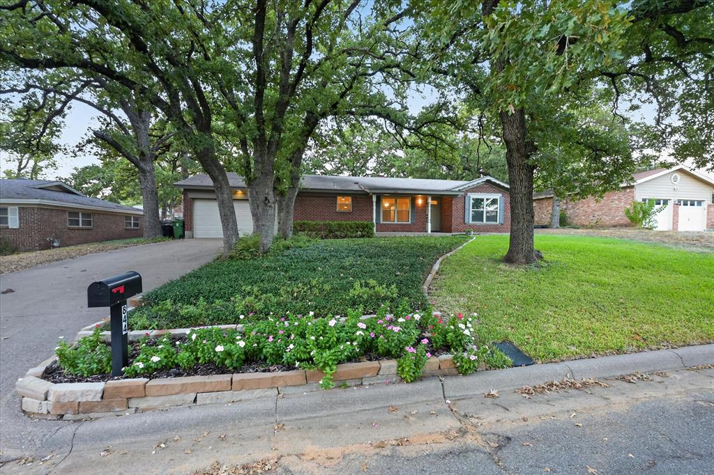 Welcome home to 844 Woodcrest Dr, a turnkey single-story brick home on a lush, canopy-shaded lot in Hurst. Featuring an open-concept floor plan designed for effortless living and entertaining, this 3-bedroom, 2-bathroom home with a 2-car garage combines modern updates with exceptional functionality. Step inside off the foyer to discover an inviting main living space centered around a curved brick fireplace. Directly off the entry sits a massive flex-bonus room that's perfect for a dedicated home office, secondary living room, play room, or a private 4th bedroom option.   The updated kitchen comes appointed with granite countertops, crisp white shaker cabinets, neutral subway tile backsplash, stainless steel appliances, and a central island bar opening to the dining area. The primary suite features a walk-in closet and a remodeled ensuite bath equipped with a modern double-sink vanity and a walk-in tiled shower with a glass enclosure. Additional highlights include an oversized laundry and mudroom with built-in storage and direct garage access. Outside, the private backyard is anchored by mature shade trees and a spacious concrete patio made for weekend gatherings.   Ideally situated in the highly regarded Hurst-Euless-Bedford (HEB) ISD, this home offers unbeatable convenience with quick access to major highways, local shopping, dining, and everyday amenities.