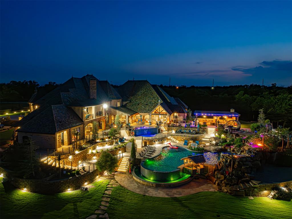 ULTRA LUXURY ESTATE in OKC! Welcome to an unparalleled sanctuary of luxury and sophistication. This one-of-a-kind gated estate, set on 36 breathtaking acres, offers an extraordinary 19,000 square feet (MOL) of meticulously crafted living space. This home comes furnished (with some reserved personal items). The property's outdoor amenities are nothing short of spectacular. A resort-like 70,000-gallon pool, complete with a slide, grotto, and expansive hot tub, serves as the focal point of multiple outdoor living areas. Entertain effortlessly with a full outdoor kitchen and a private, stocked pond, all within the security of a gated entry. Savant Home Automation ensures state-of-the-art control and convenience throughout the estate. This exquisite property features a stunning koi pond, home to over 200 brightly colored koi fish. Other amenities: electric shades, generator, hidden staircases, multiple bar areas, golf driving balcony, fireman's pole from kids gaming area to kitchen, etc. Indoors, the residence boasts dual professional bowling alleys, a game room, a large office suite, and soaring ceilings. A $6M 32,000-square-foot barn (heated & cooled and NOT included in sf)) elevates the property further, featuring an indoor basketball court, a full outdoor basketball court (outside of the barn), multiple bar areas, a dance floor, and a performance stage. The barn includes 33 oversized car garages, providing plenty of space for car collectors and extra storage. This entertainment hub even includes an elevator for ultimate convenience. 2 oversized his/hers bedroom suites are also inside barn. Experience a lifestyle of unparalleled luxury and distinction in this remarkable estate, where every detail has been thoughtfully curated for the discerning homeowner. Professionally decorated with custom furniture from all over the world! The home currently has a full-time live-in house manager that runs the entire property.