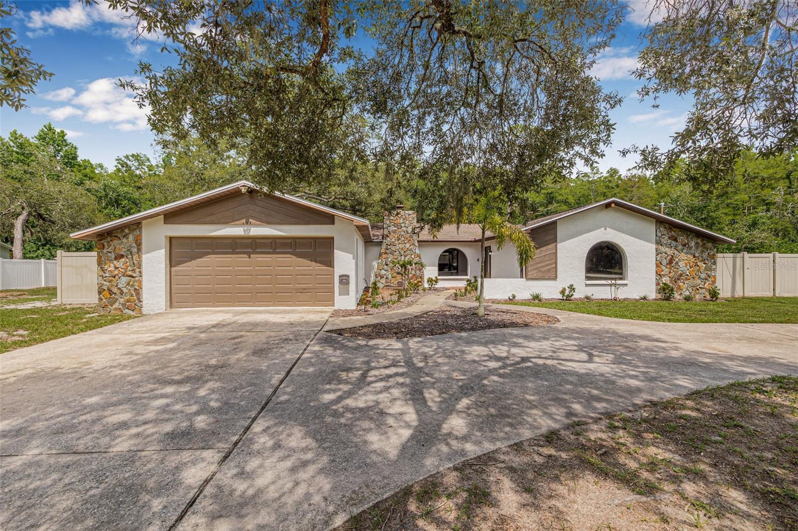 Tucked away on nearly 2 acres in the desirable Golden Acres community, this 4-bedroom, 2-bathroom pool home offers exceptional privacy, a peaceful conservation backdrop, and plenty of room to make it your own. With 1,968 square feet of living space, a split floor plan, and two separate living areas, the layout is ideal for everyday comfort and effortless entertaining.

Inside, you’ll find a well-maintained home with endless potential for modern updates. The kitchen features stainless steel appliances and opens to a cozy living room with a wood-burning fireplace. Fresh interior and exterior paint enhances the home’s bright, welcoming feel.

Step outside to a screened-in pool and an expansive backyard oasis. There’s a ton of deck space on the screened-in patio—perfect for lounging, dining, or entertaining outdoors. The fully fenced dog run offers a secure space for pets, while PVC fencing along the sides adds extra privacy and frames peaceful views of the conservation land beyond, offering unmatched tranquility and seclusion.

With nearly 2 acres of land, there’s ample space to bring all your toys—boats, RVs, trailers, and more—with no HOA restrictions holding you back.